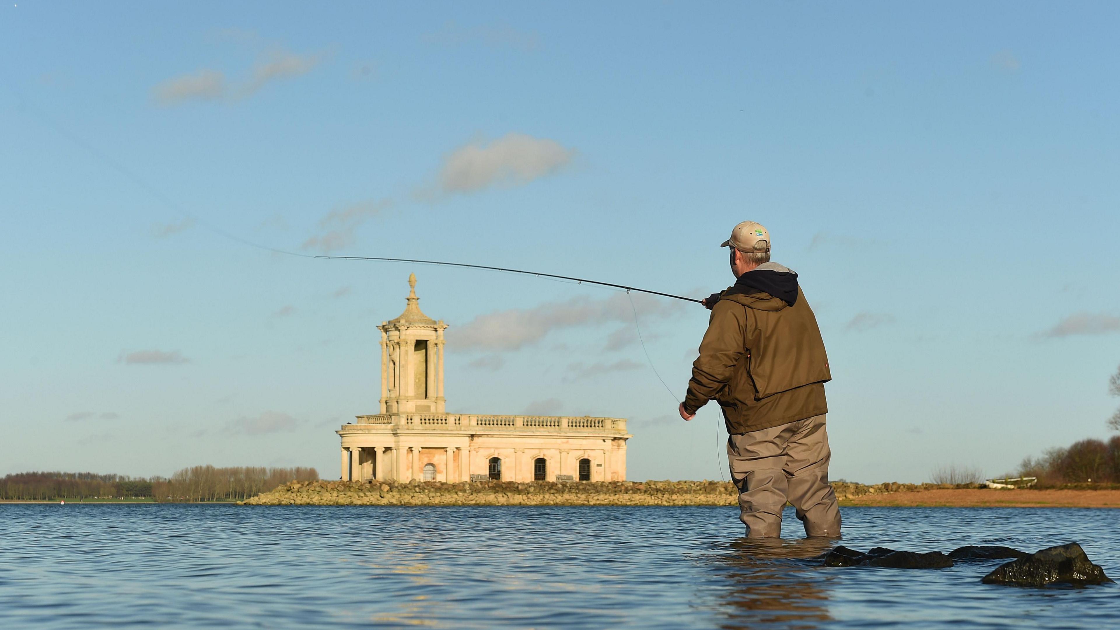 An angler trying his luck in the shallows of Rutland Water