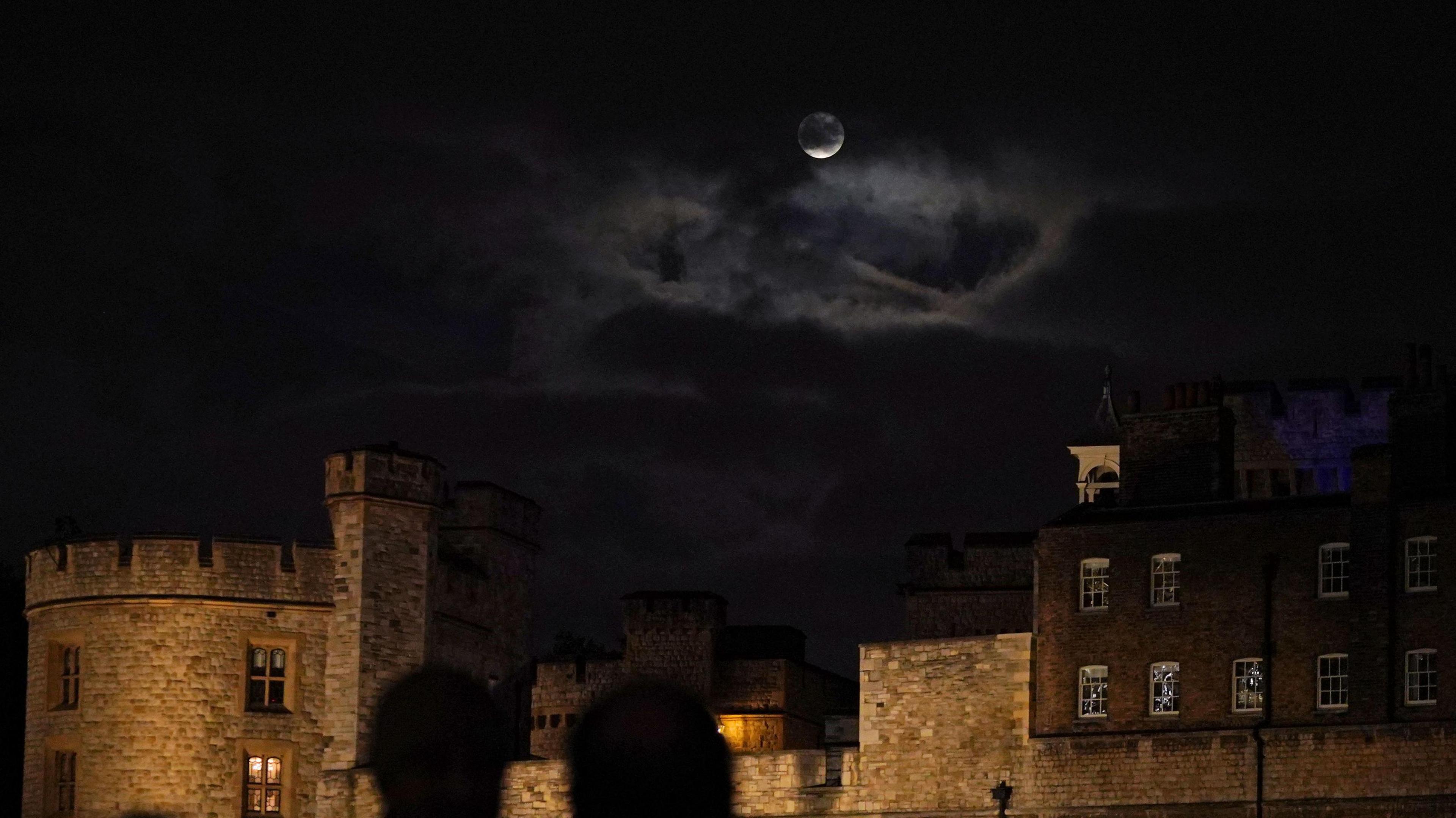 A glimpse of the supermoon through clouds over the Tower of London.