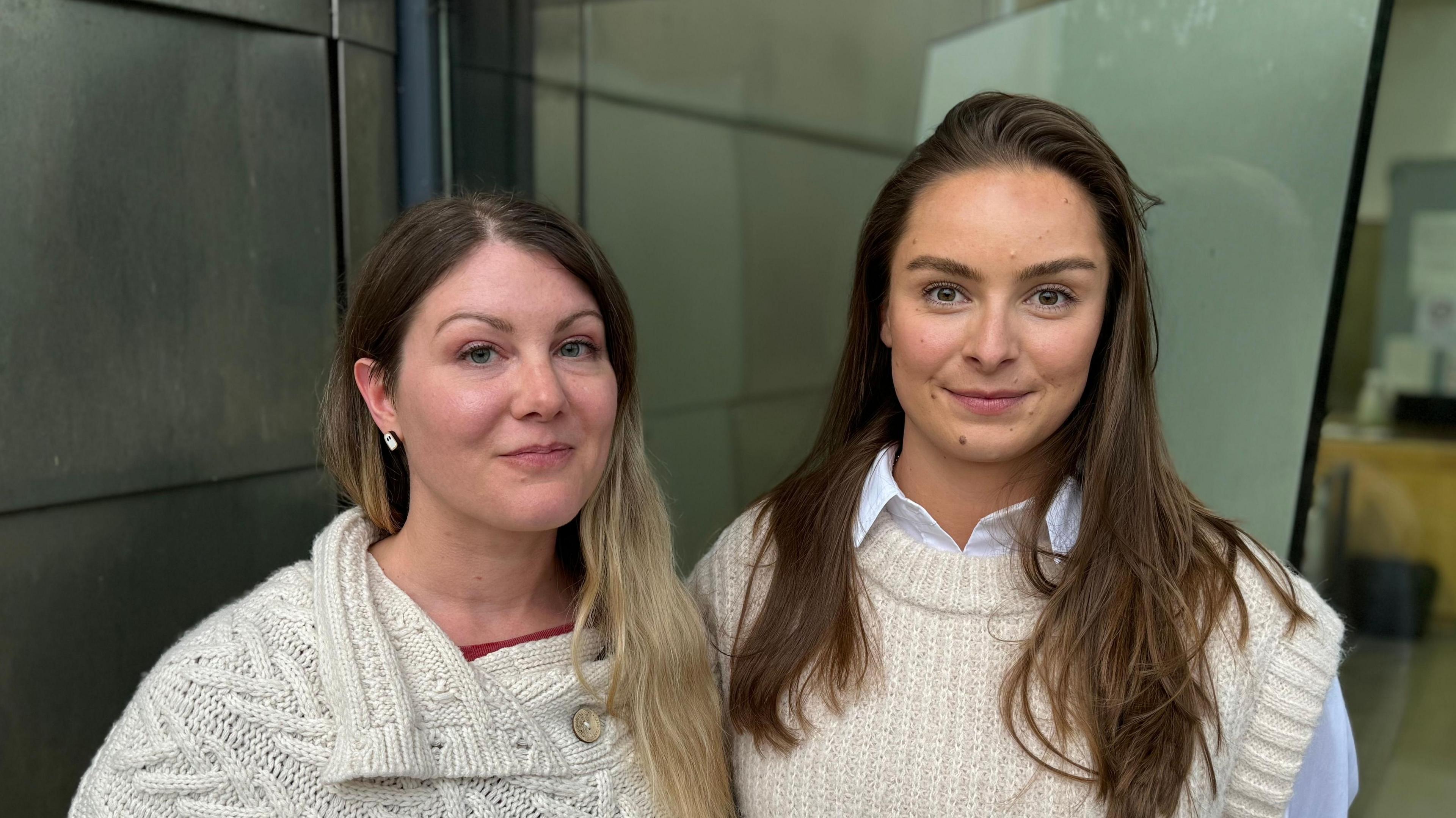 Two woman - both wearing cream coloured knit wearing - standing in front of a window at Ipswich Crown Court