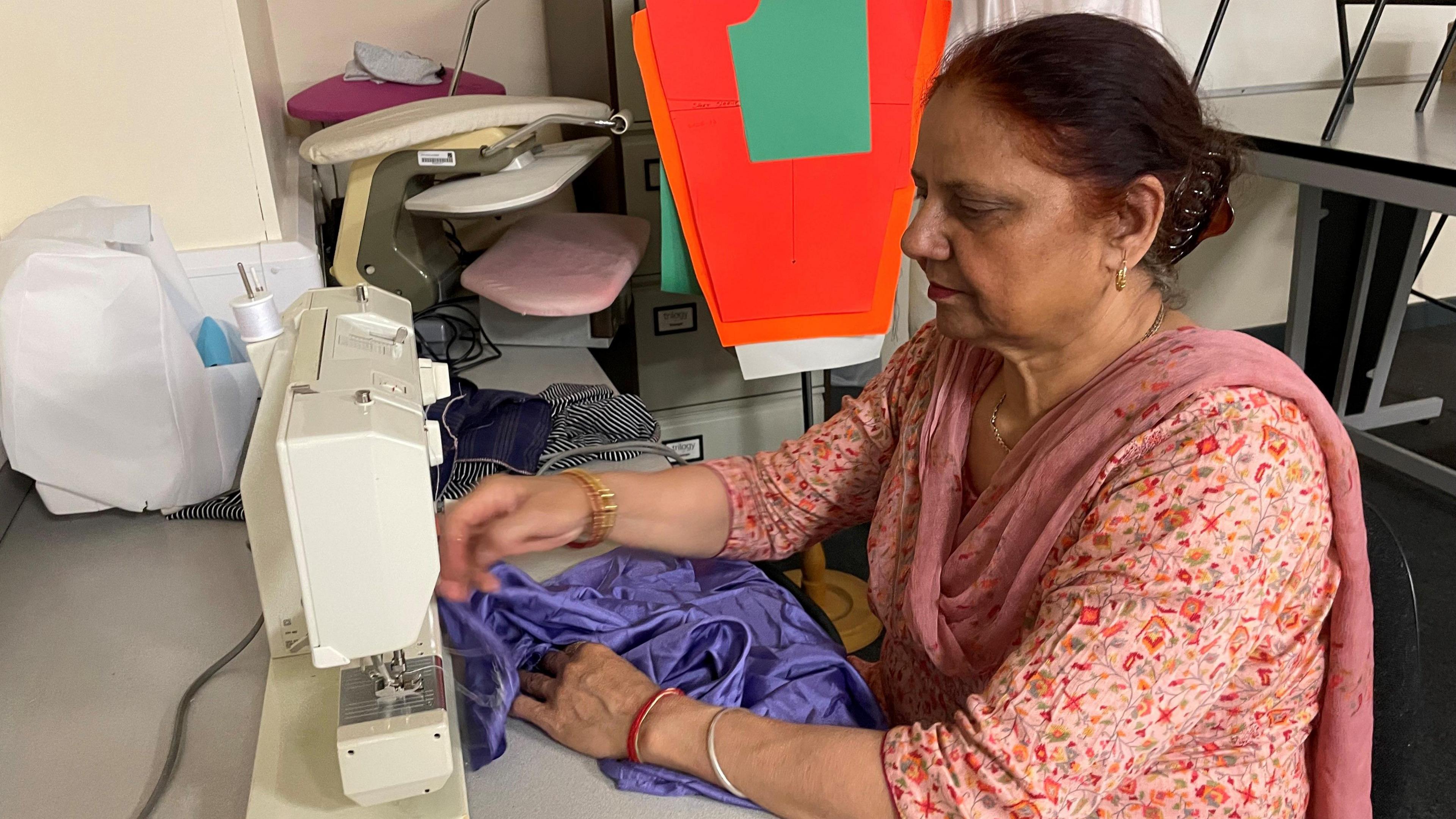 Paramjit is using a sewing machine to stitch a garment