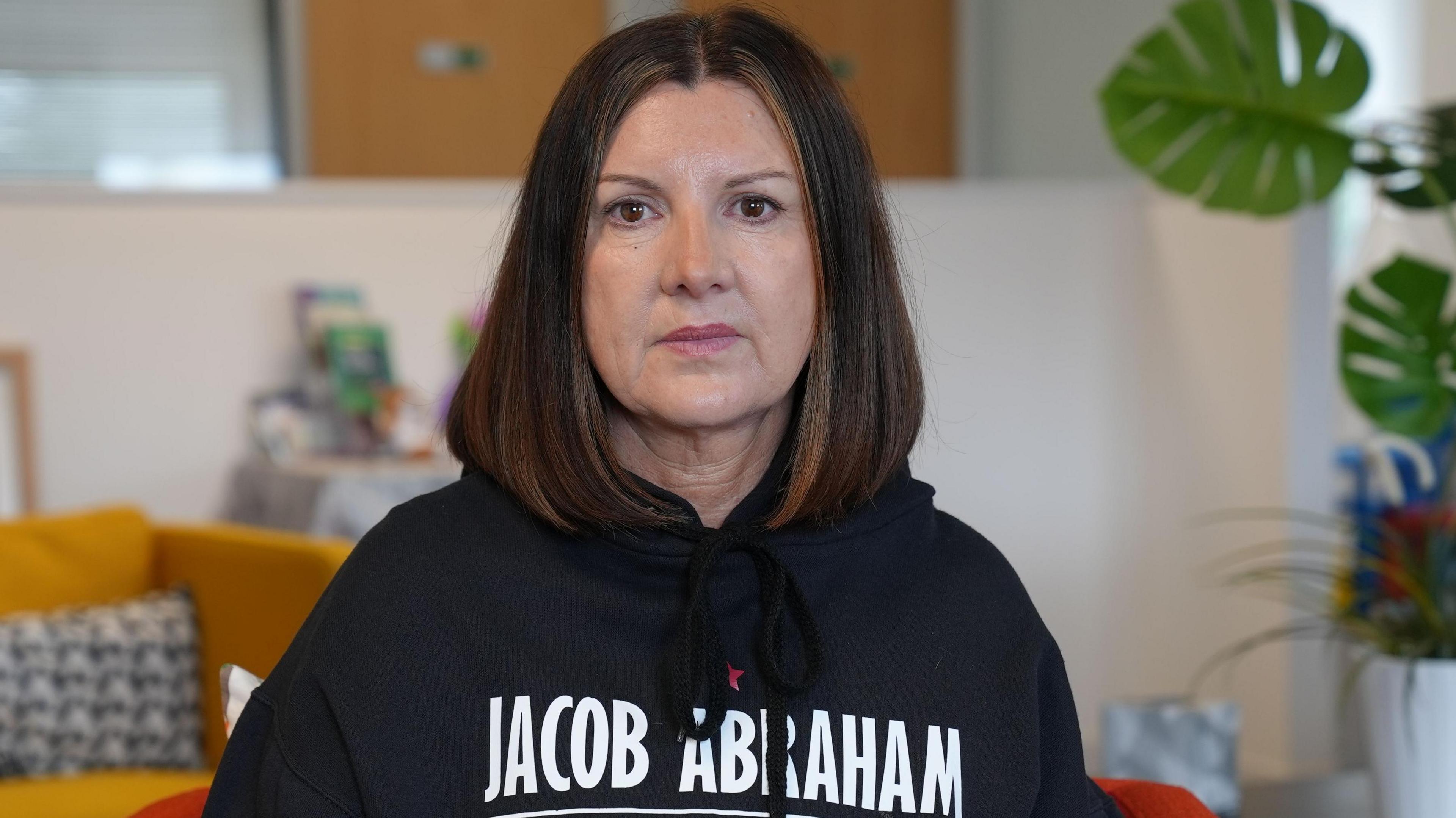 Woman in a black hoody looking at the camera