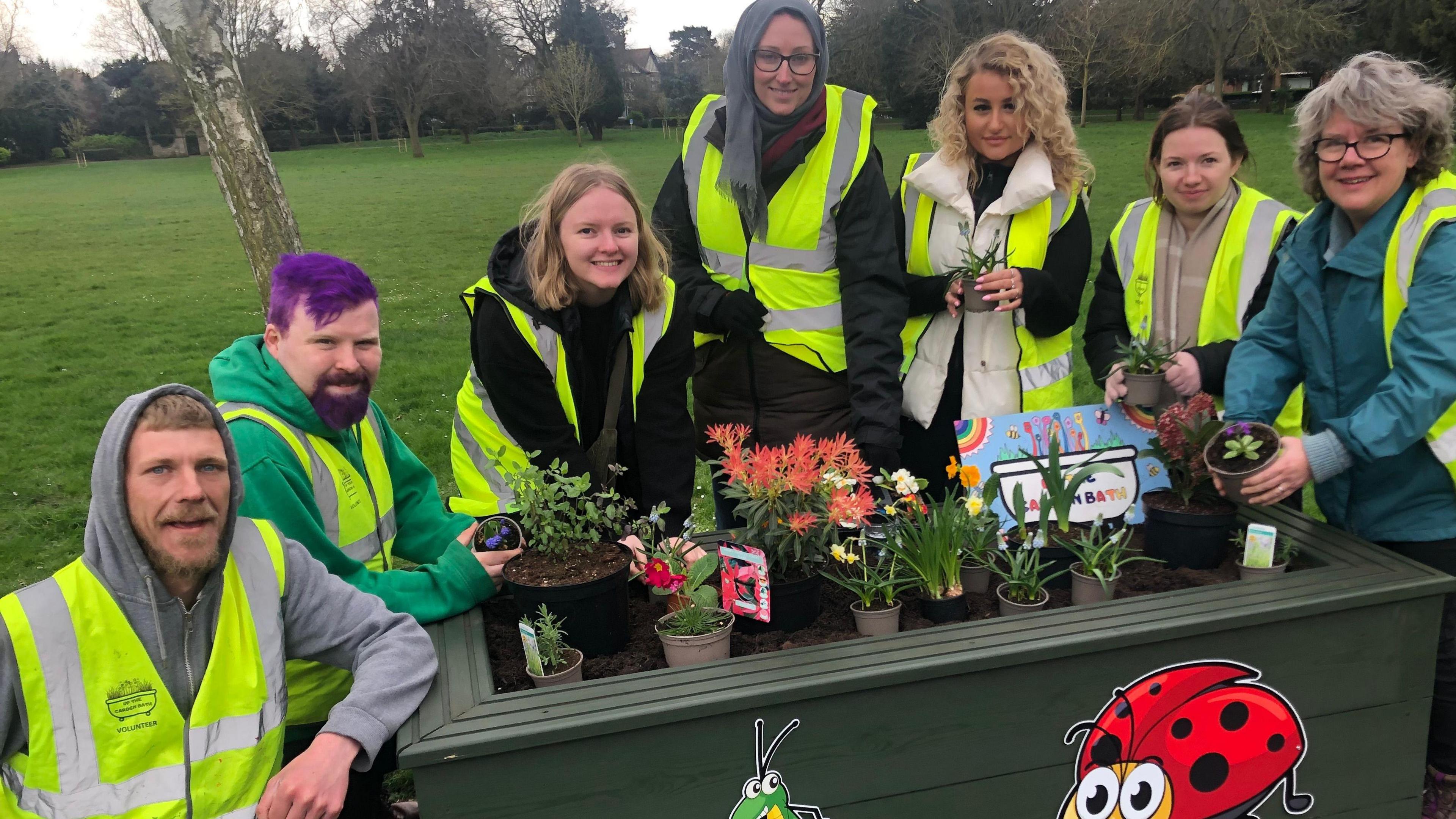 Group of volunteers with he upcycled bath tub