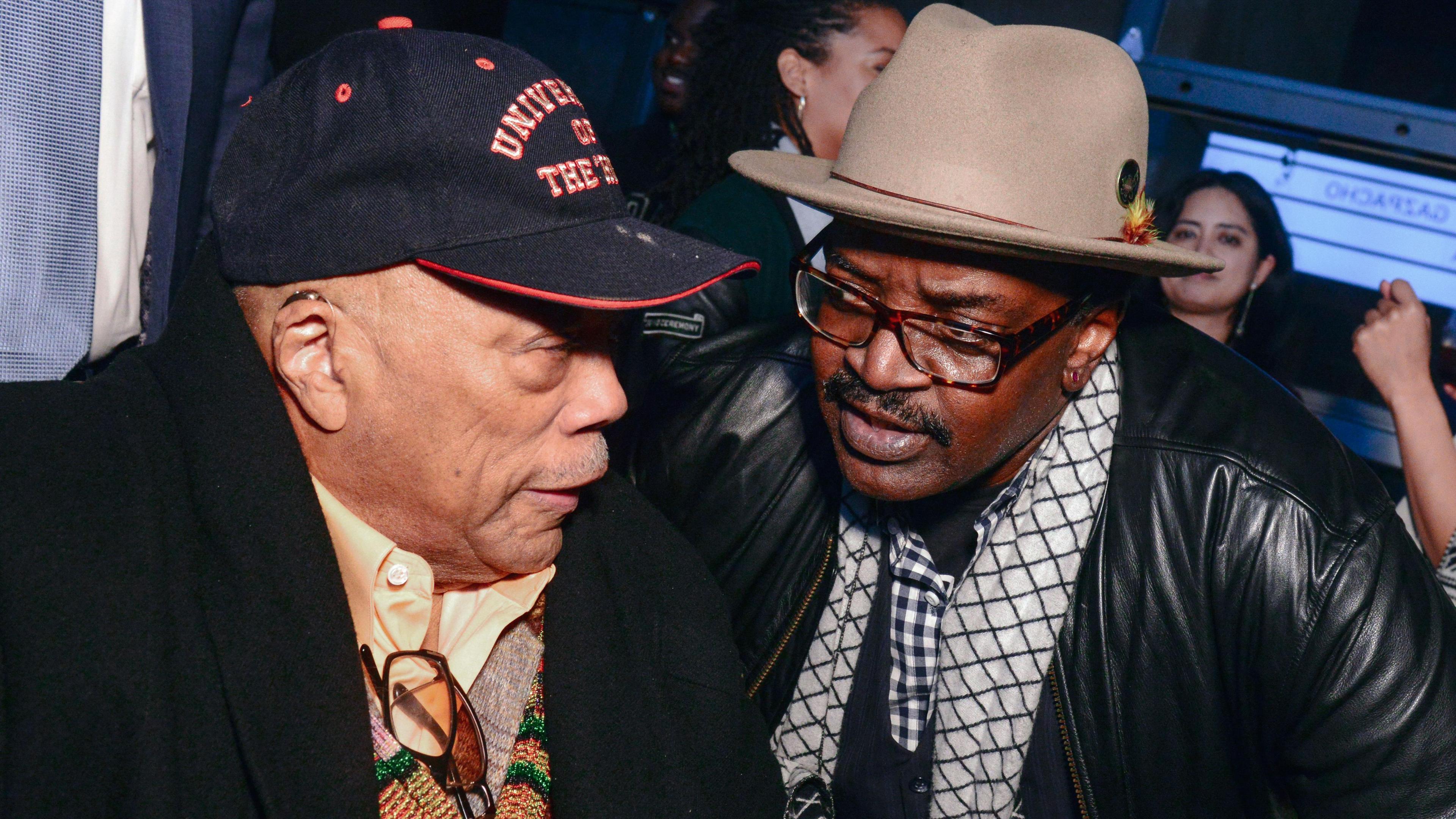 Quincy Jones Fab 5 Freddy speaking together in 2019. Jones is wearing a black baseball cap and Freddy has a beige trilby on