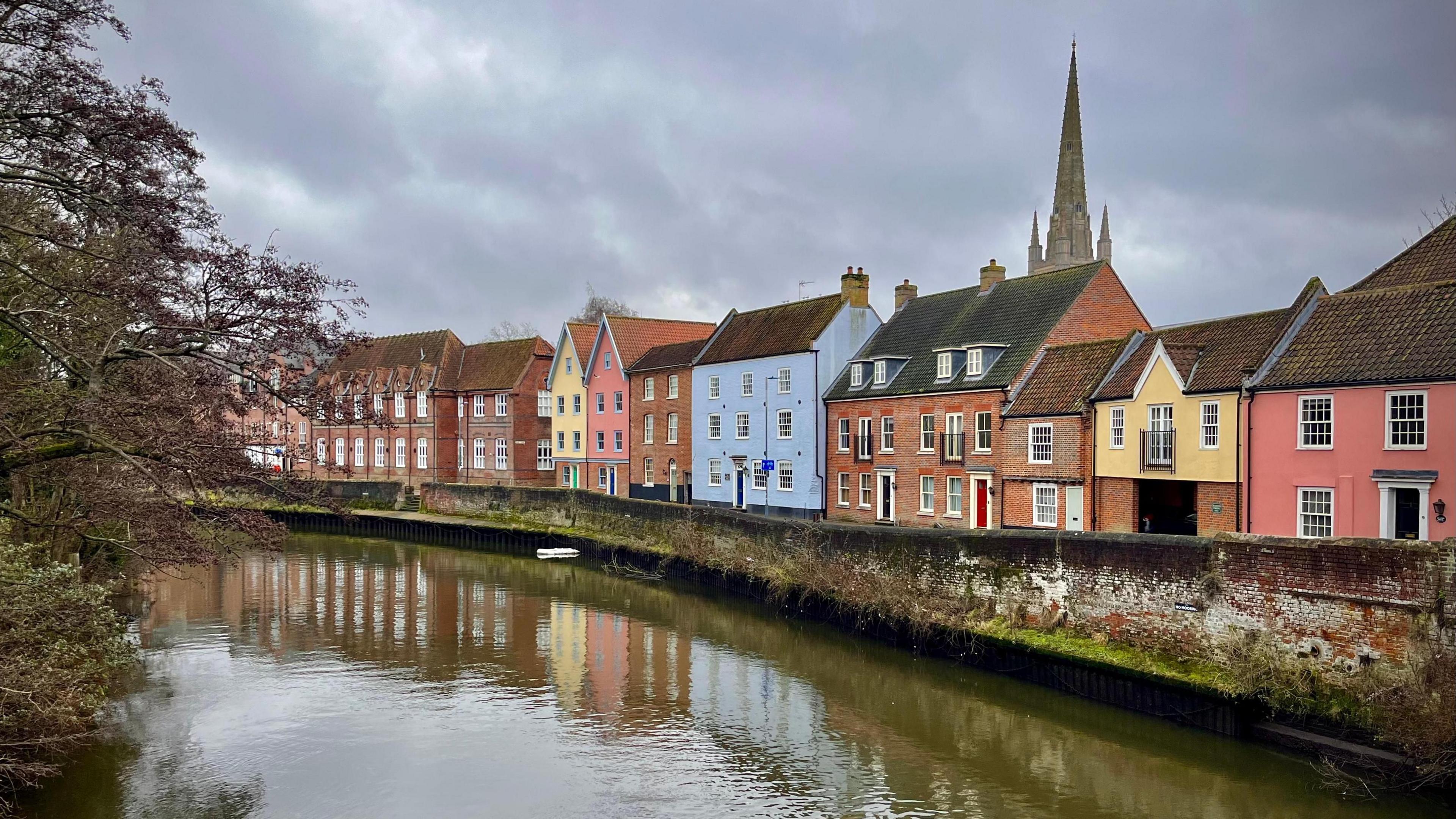 A row of colourful houses in Norwich by the River Wensum.