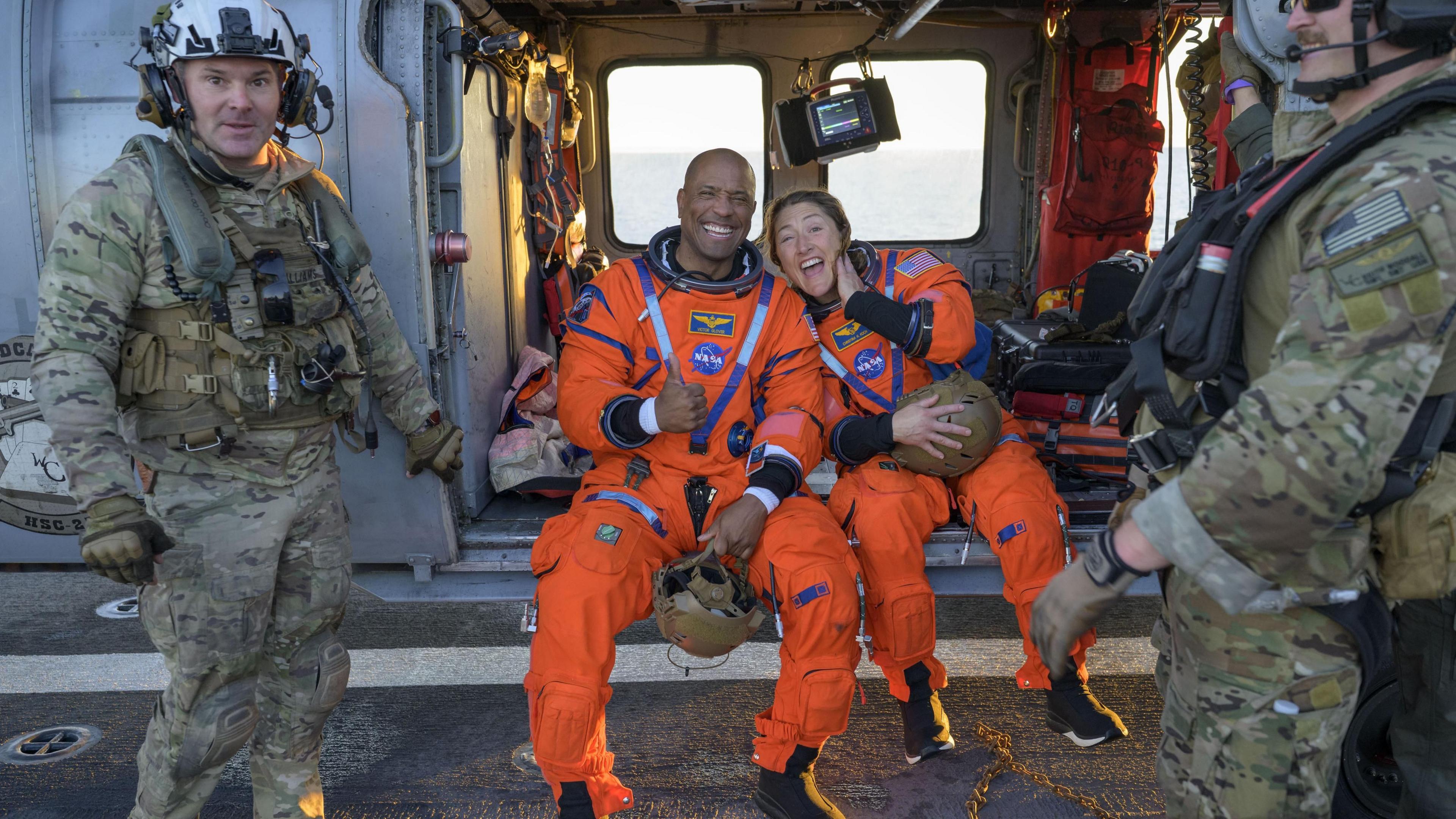 Victor Glover and Kristina Koch grin at the camera from their helicopter. 