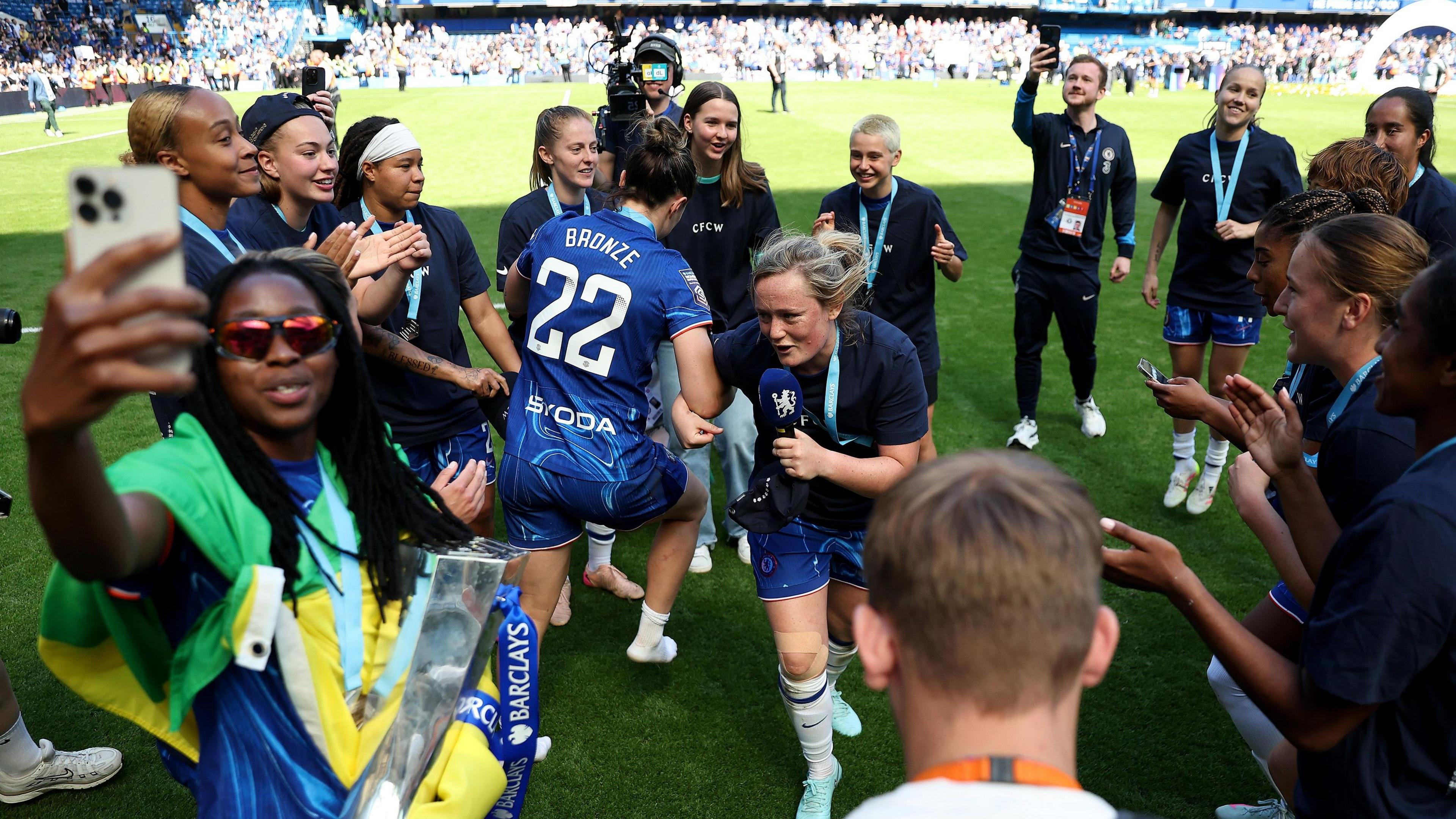 Erin Cuthbert and Lucy Bronze dance on the pitch