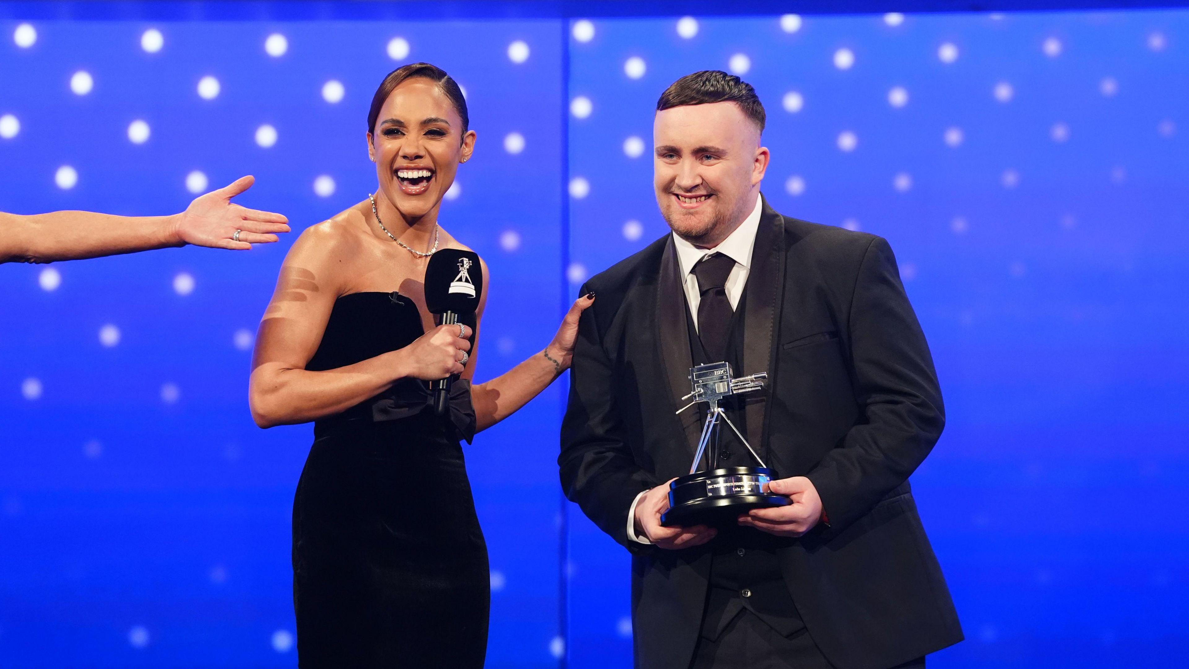 Luke Littler and the BBC Young Sports Personality of the Year 2024 award standing alongside Alex Scott during the 2024 BBC Sports Personality of the Year Awards held at MediaCityUK, Salford.