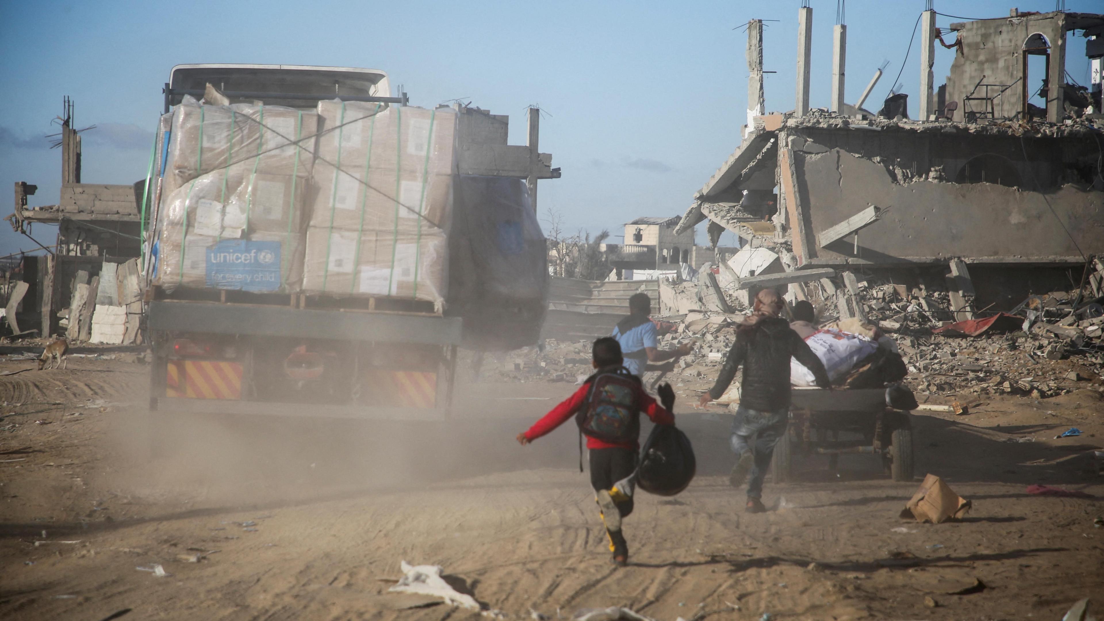 Palestinians run towards an aid lorry in Rafah, southern Gaza (20 January 2025)