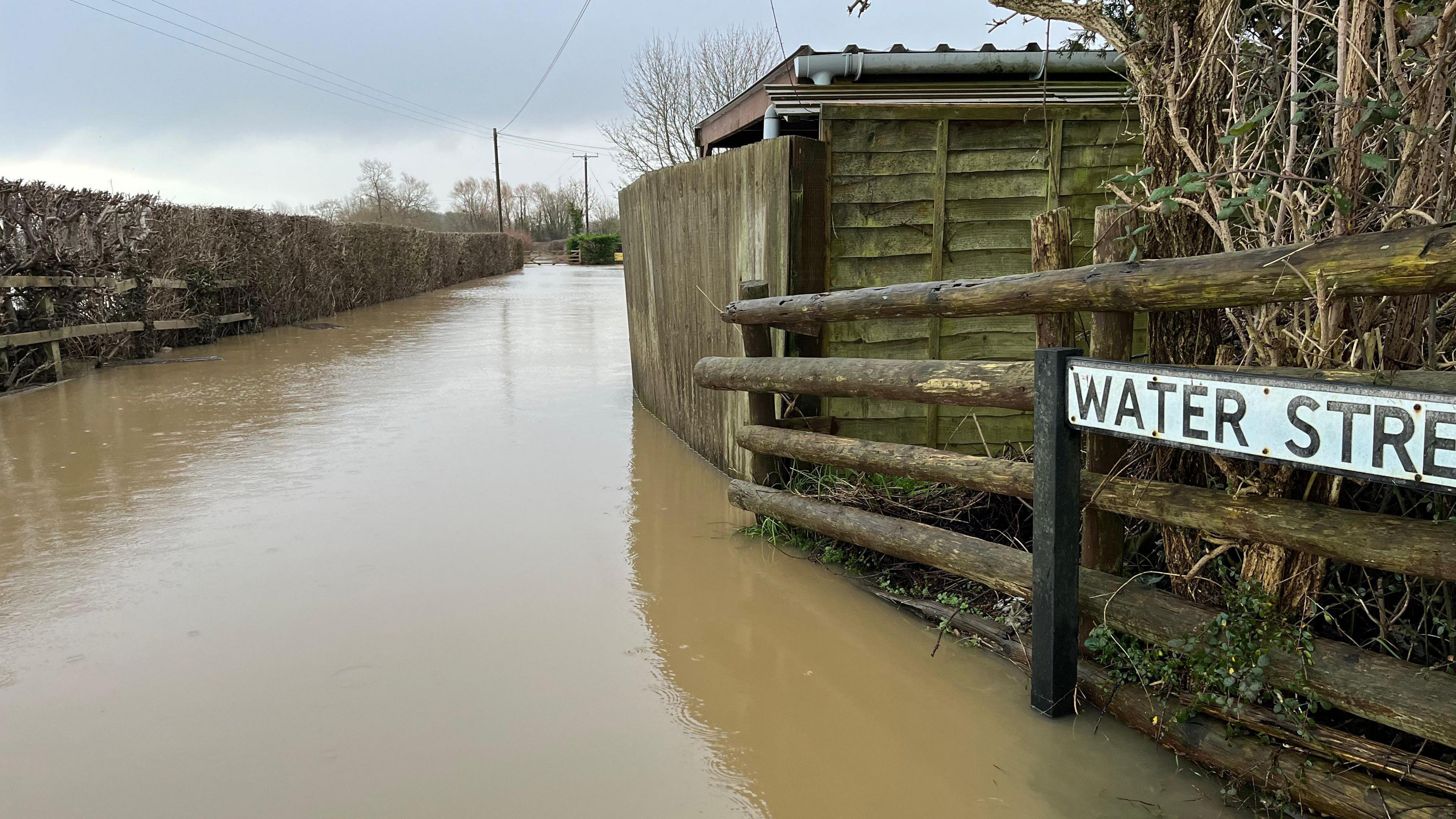 A flooded street with a sign saying 'Water Street'.