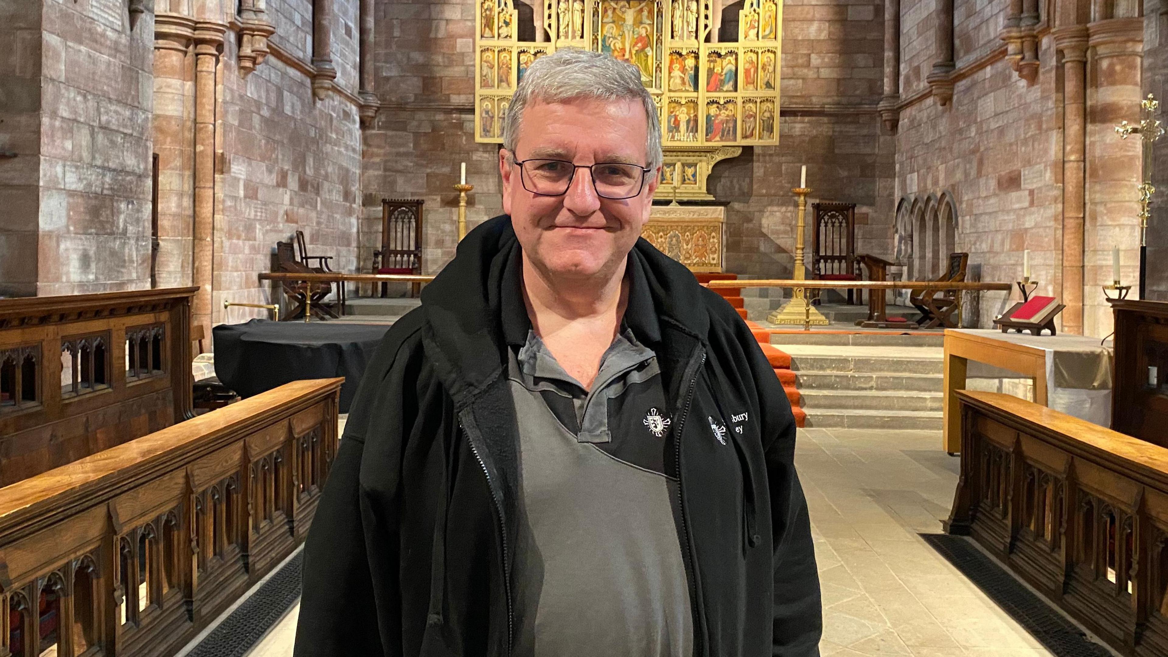 Church administrator Steve Swindon stands in the aisle of Shrewsbury Abbey, with the altar in the background