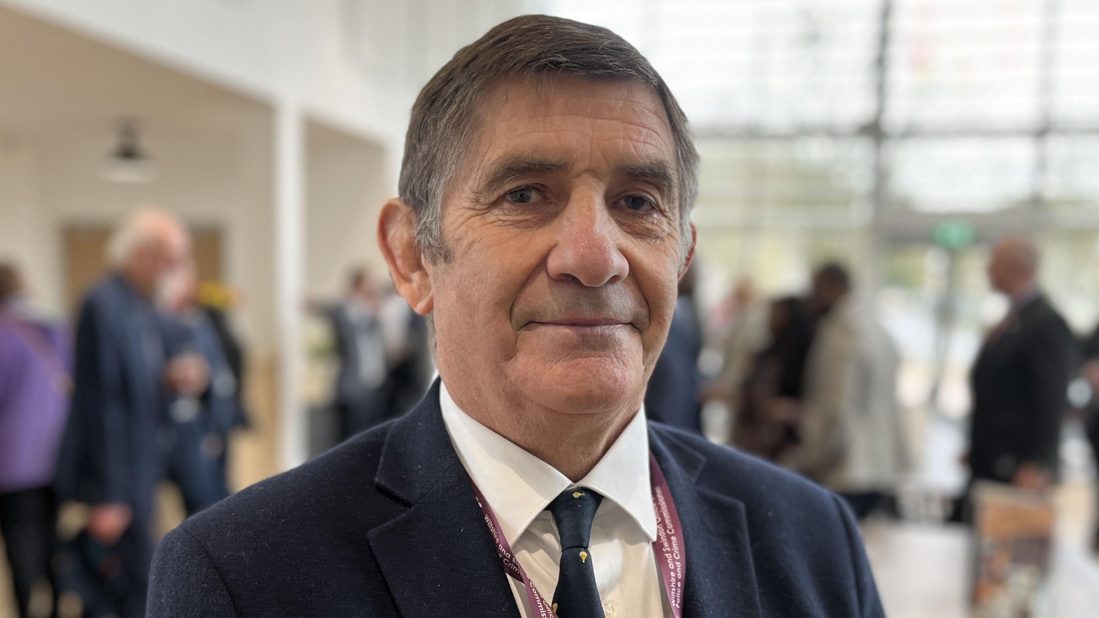 Wiltshire and Swindon's Police and Crime Commissioner, Philip Wilkinson wearing a navy blue suit, white shirt and tie