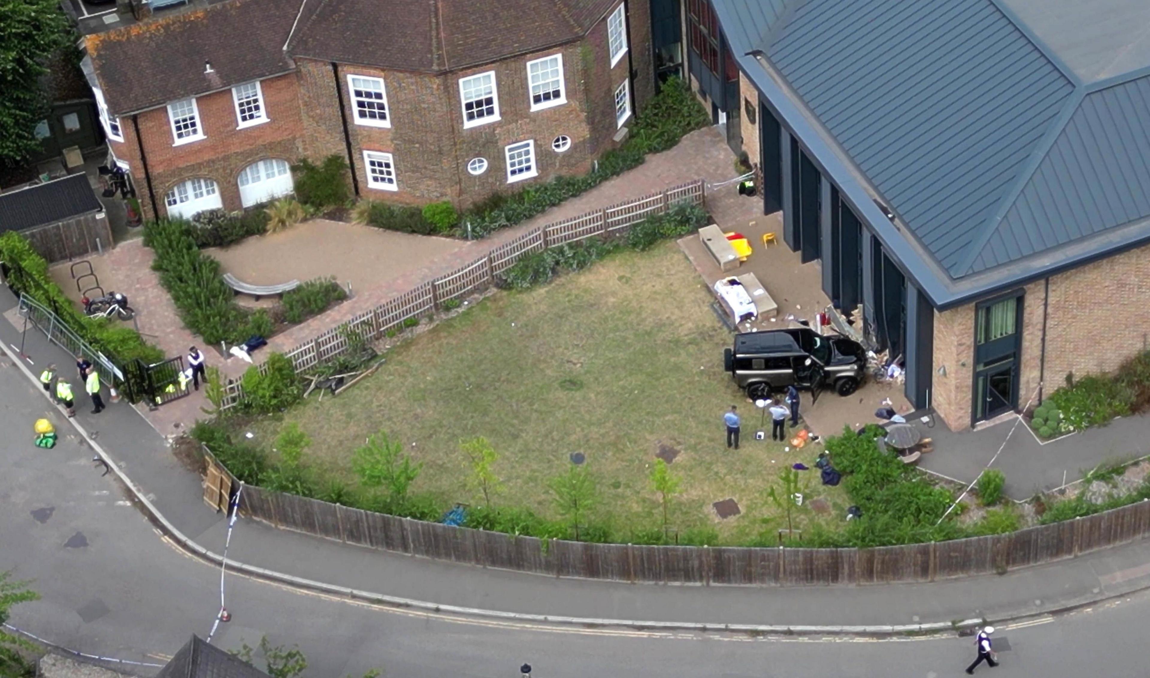 Aerial view of the scene of the black Land Rover crashed into the school playground with police and equipment strewn on the ground