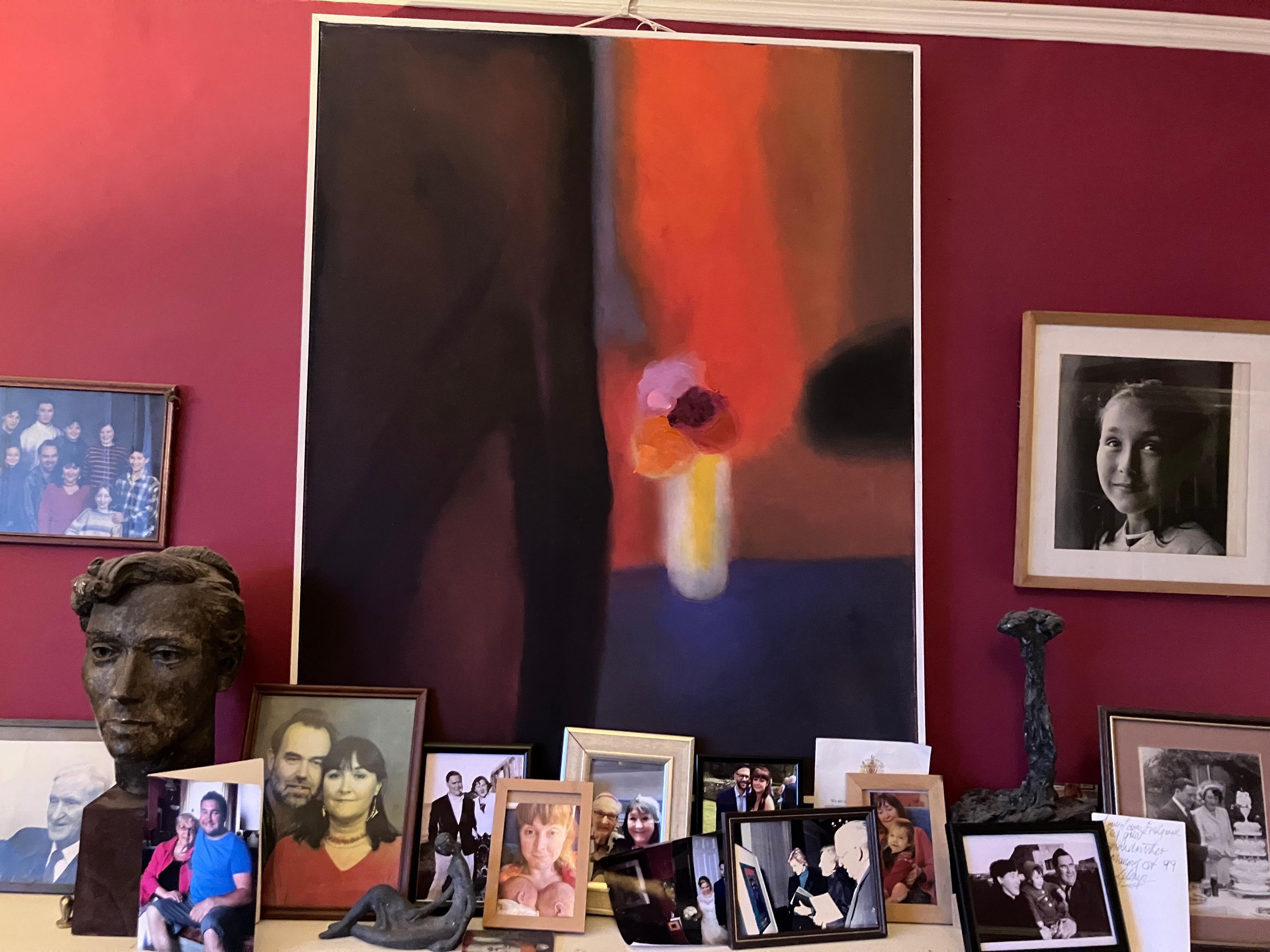 One of Glenys' paintings surrounded by family photographs and a bust of her made by Ronald 