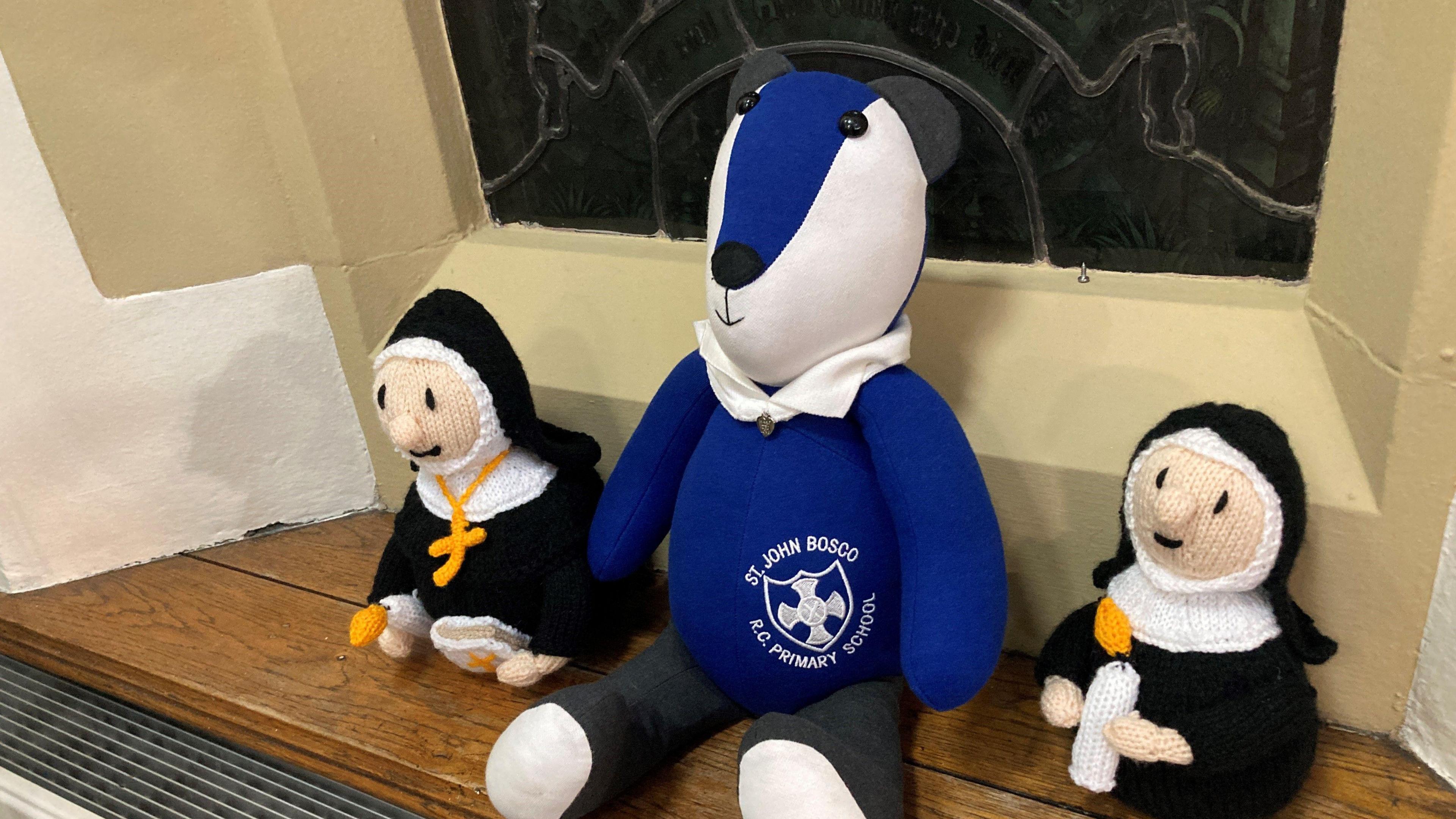 School mascot and and knitted nuns sitting on windowsill