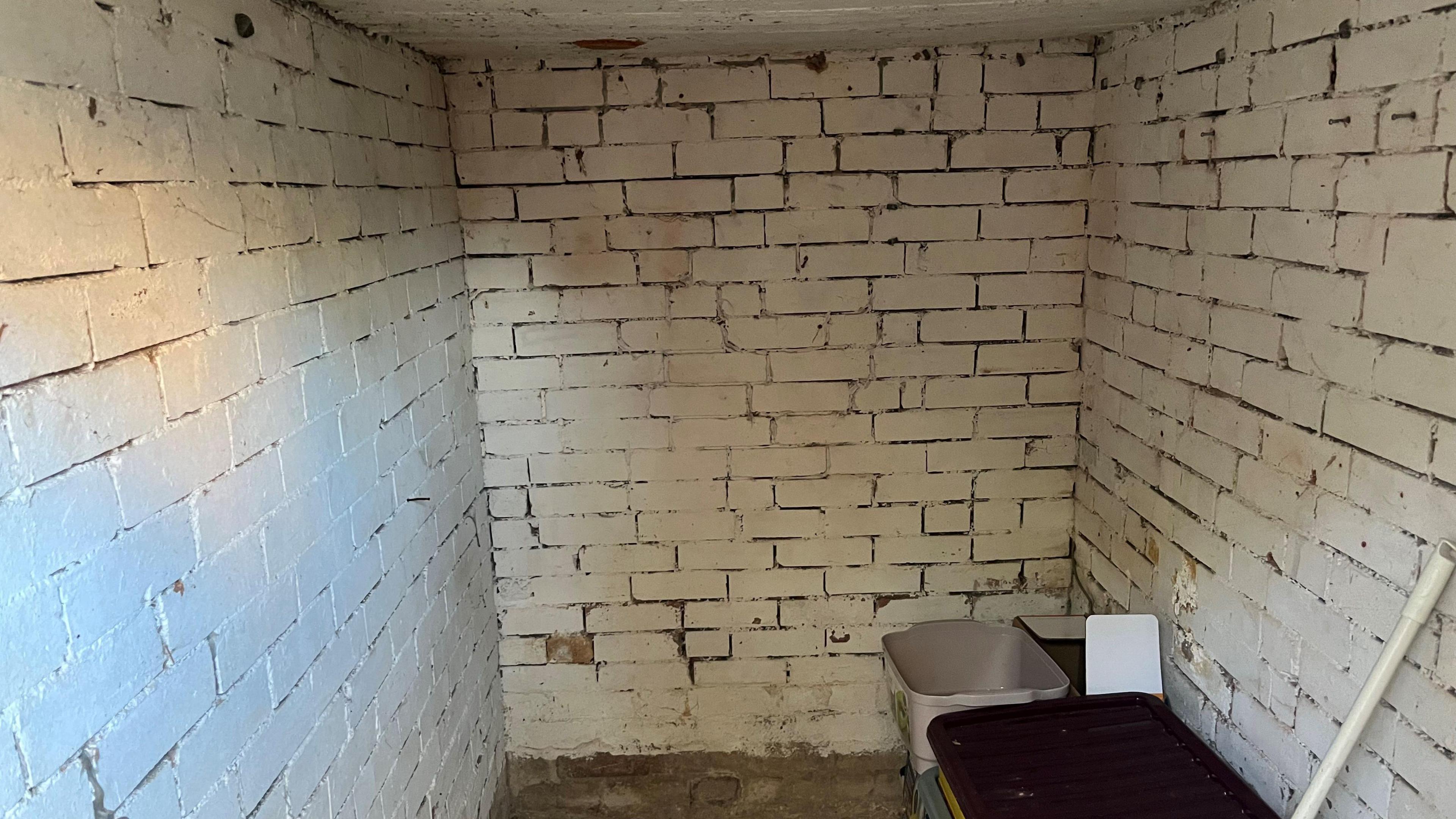 A white washed brick building about 2m (6 ft) by 2.44m (8 ft) and about 2m (6 ft) high.