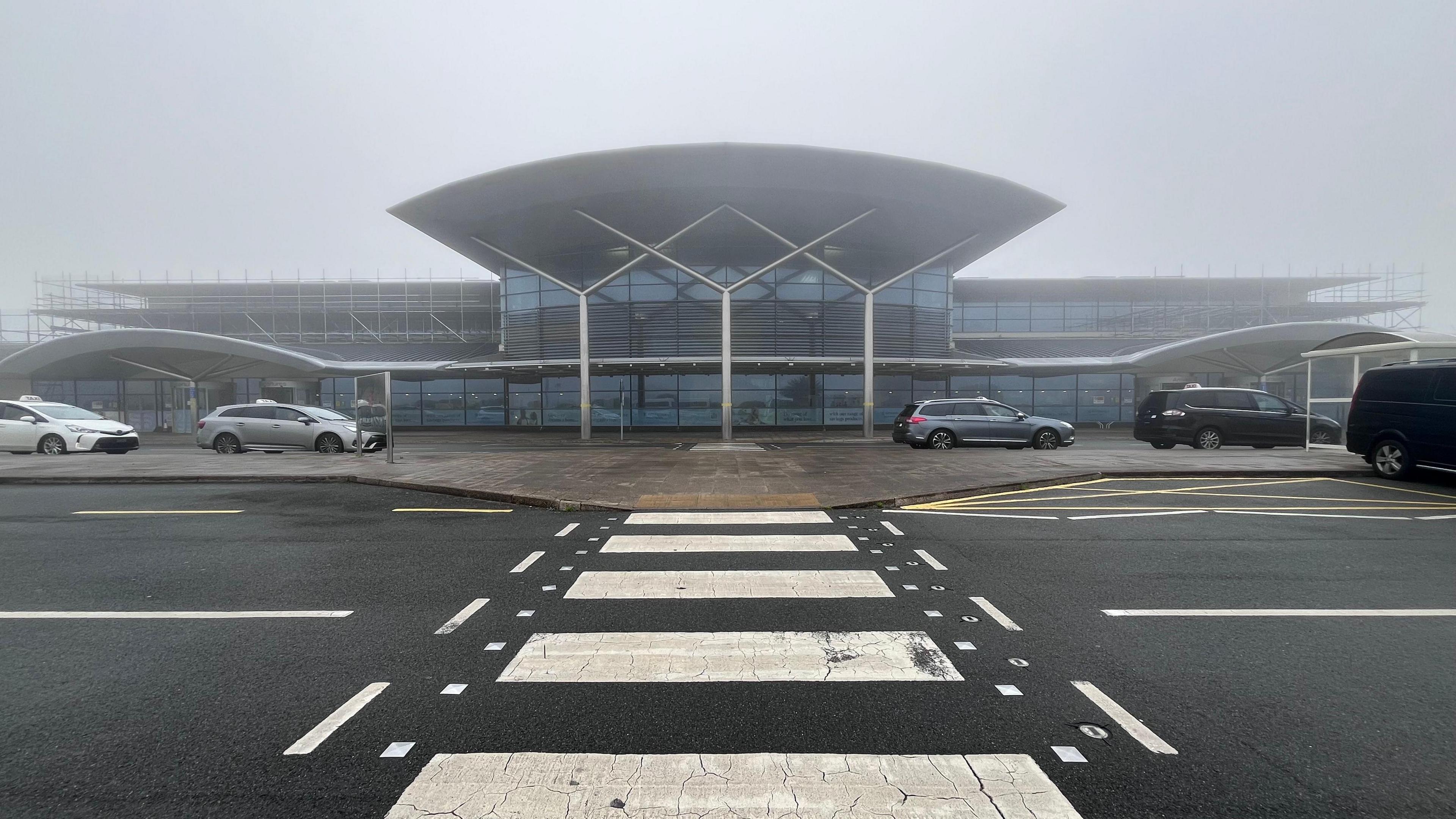 The front of a small airport on a foggy day.