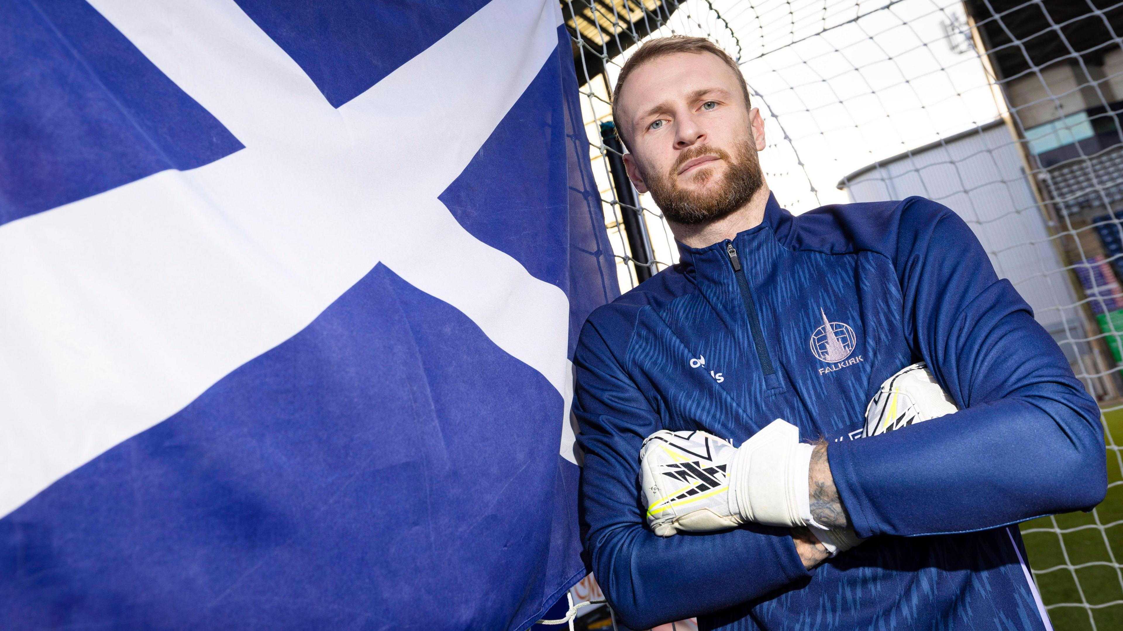 Scott Bain poses with a Scotland flag at the Falkirk Stadium