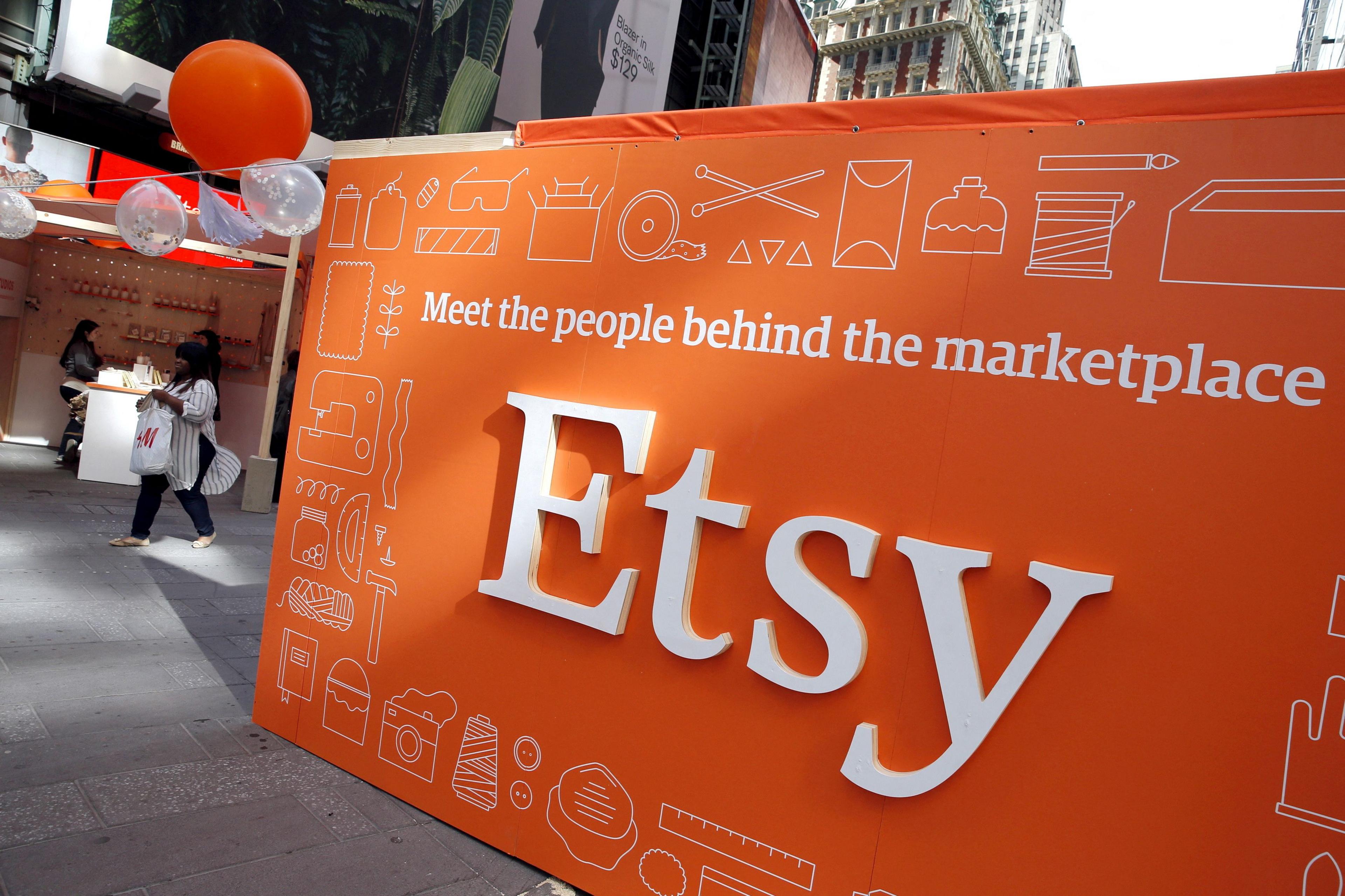 A large Etsy sign shows the company logo written in white letters on an orange background. It includes the slogan: Meet the people behind the marketplace.