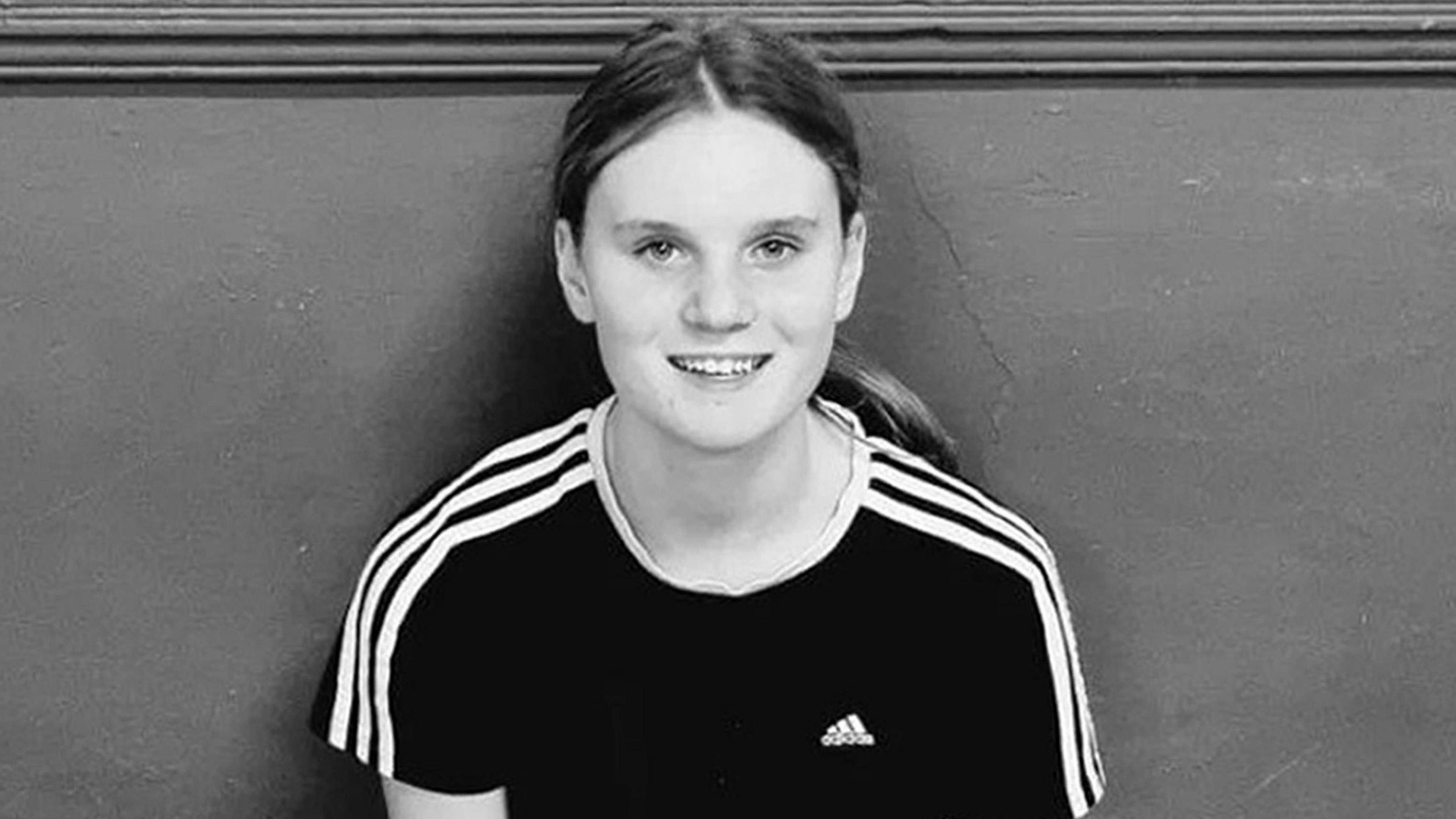 Black and white picture of a teenage girl with long hair in a pony tail