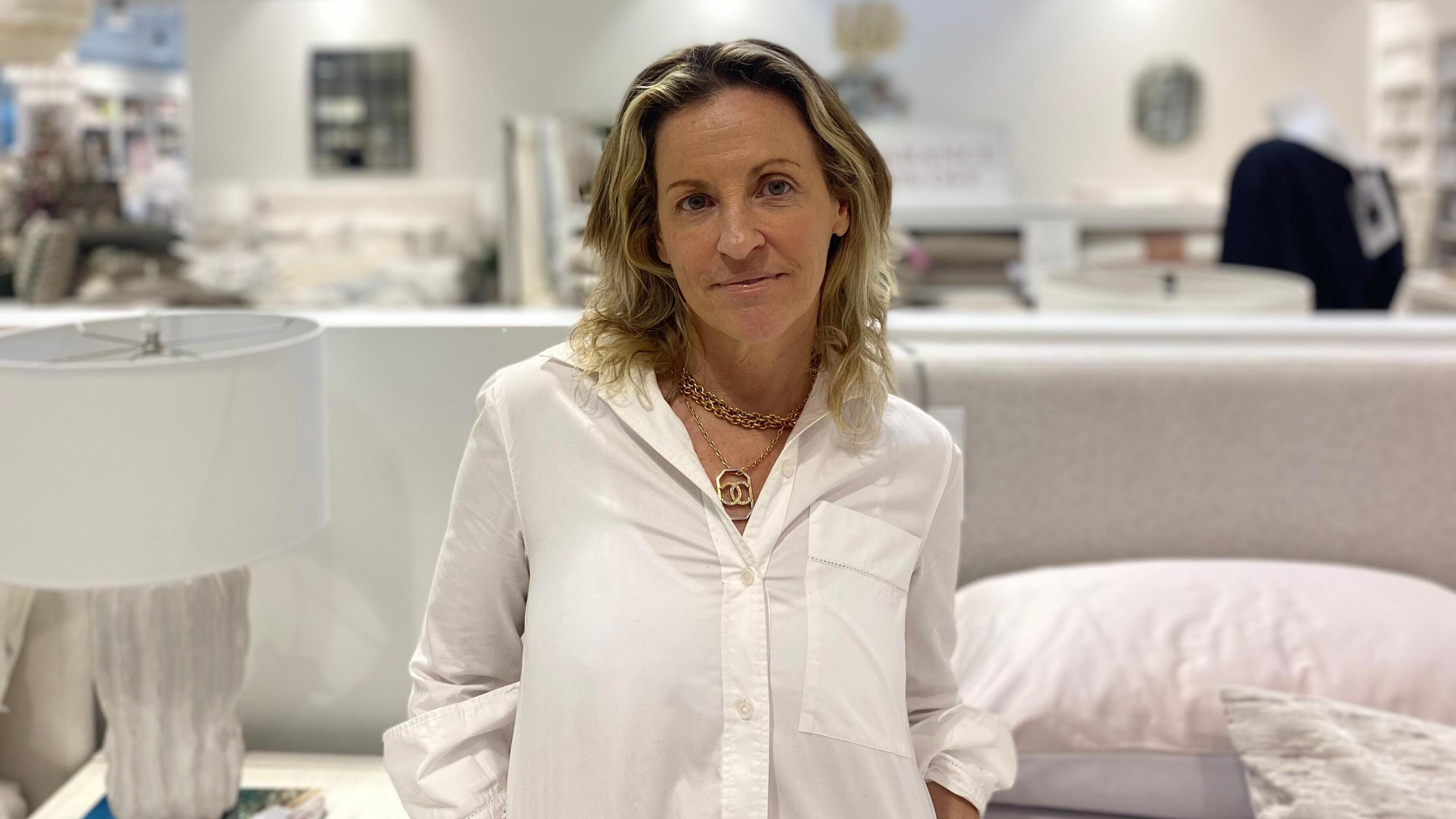 Retail boss Joanna Goodman, owner of Au Lit Fine Linens, wearing a white shirt, and looking at the camera.