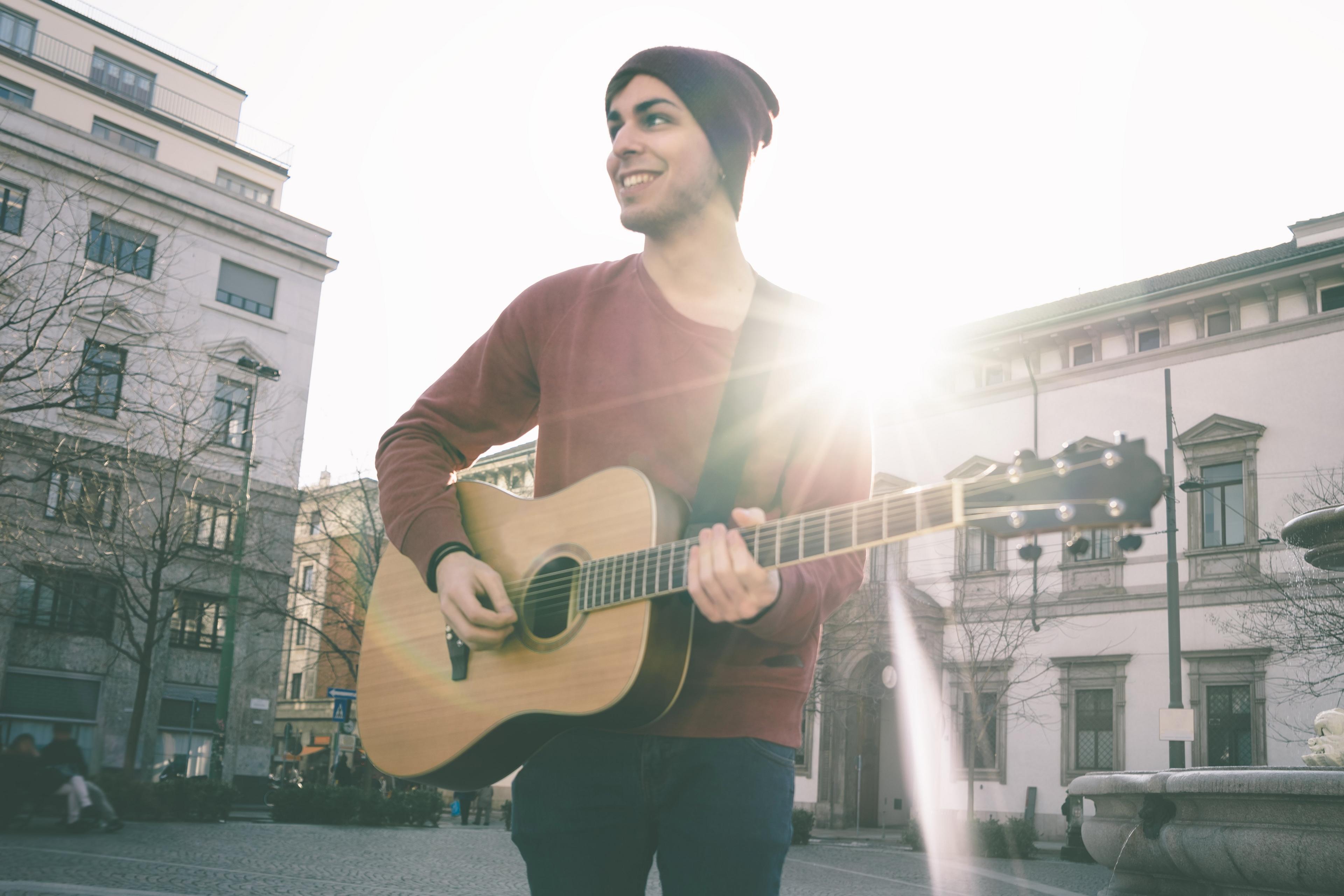 A man playing guitar in the street