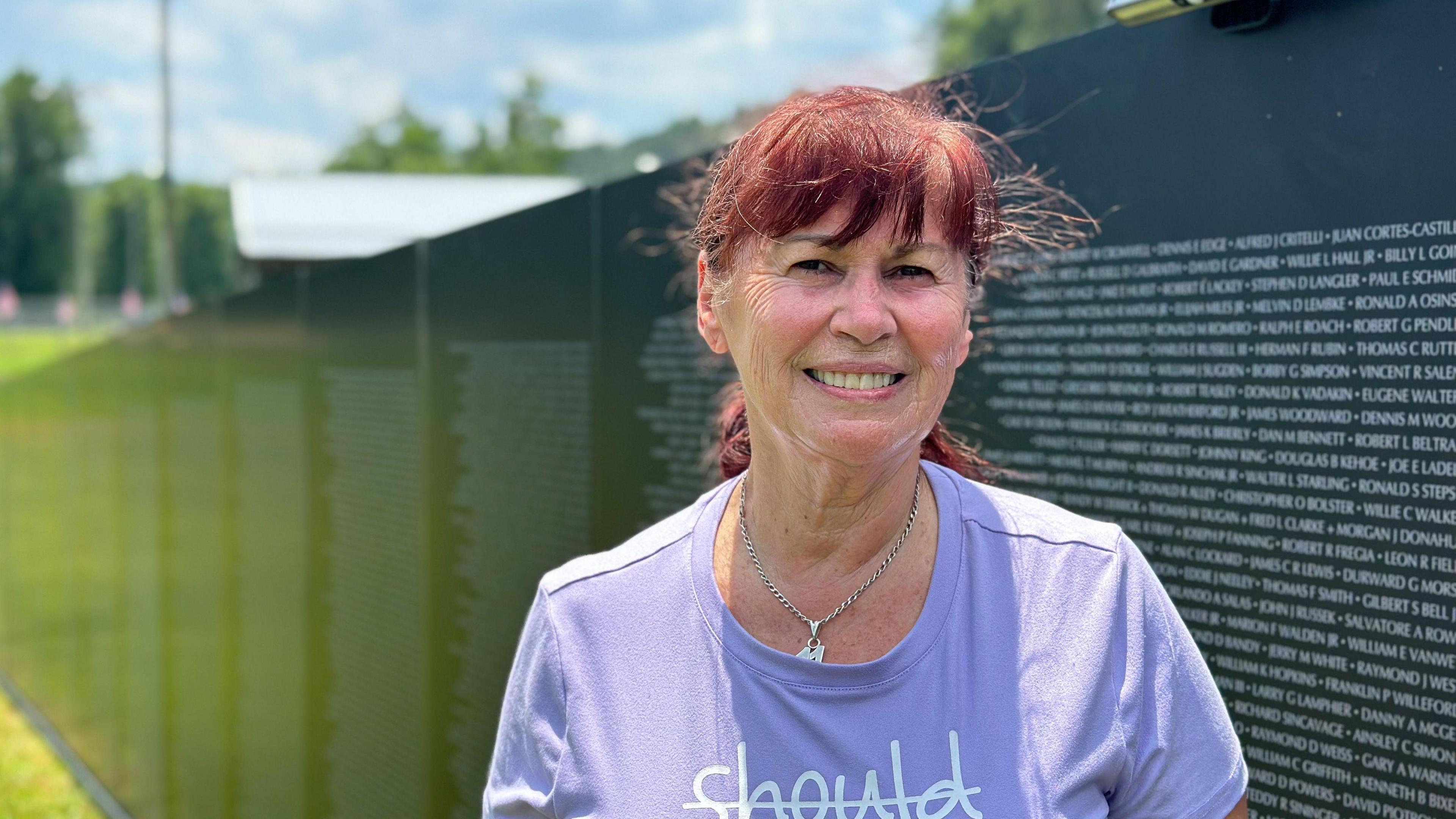 Gloria Murphy stands in front of a memorial honouring US soldiers who died in the Vietnam War 