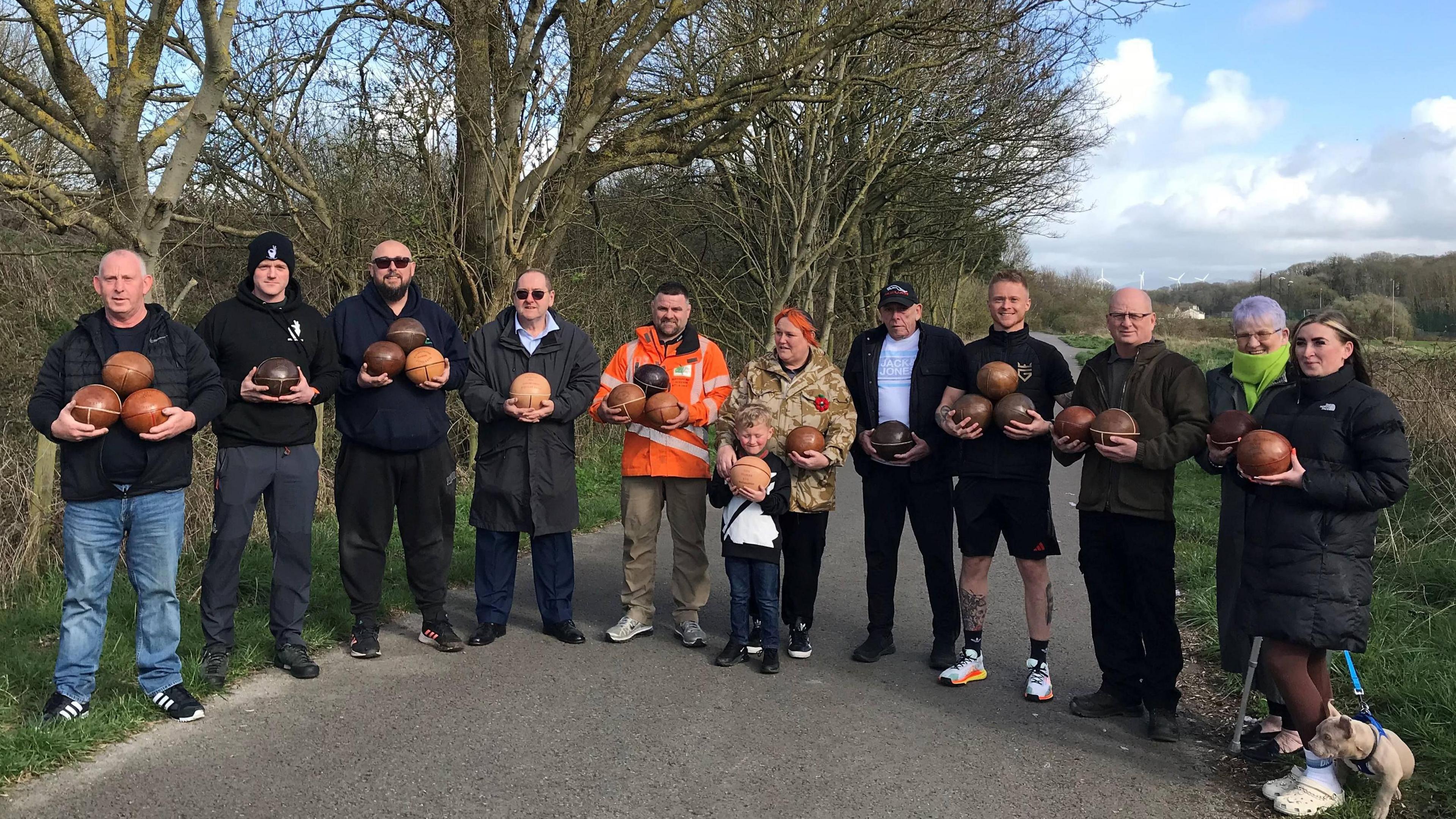 Uppies and downies players and supporters show off their balls