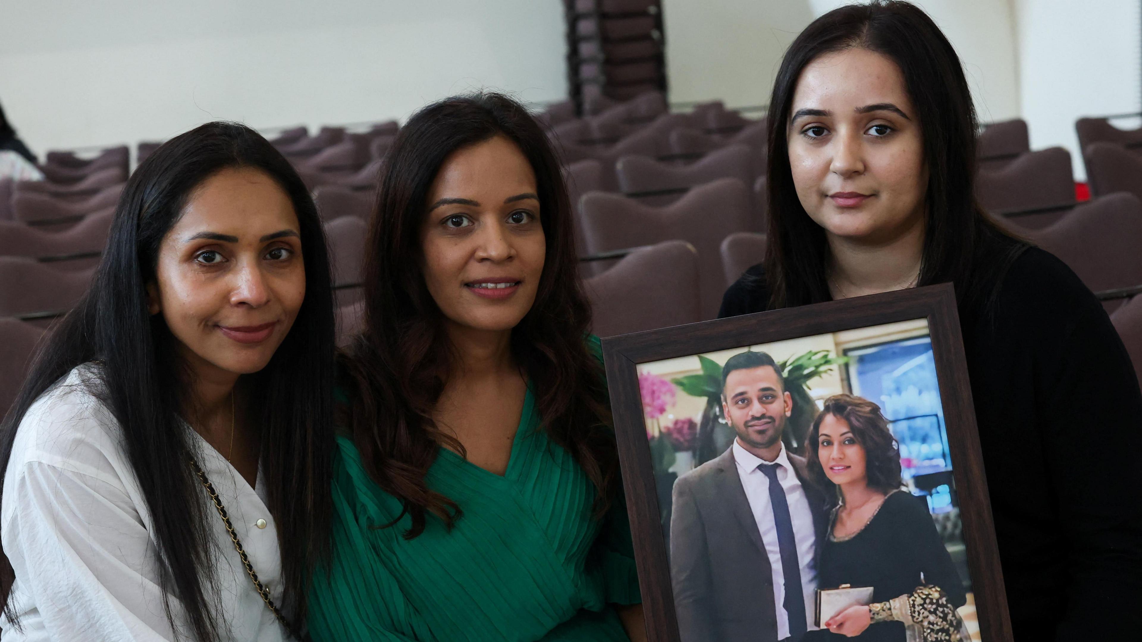 Jina and Komal Patel and Krupali Patel hold a photograph of Sunny and Monali Patel.