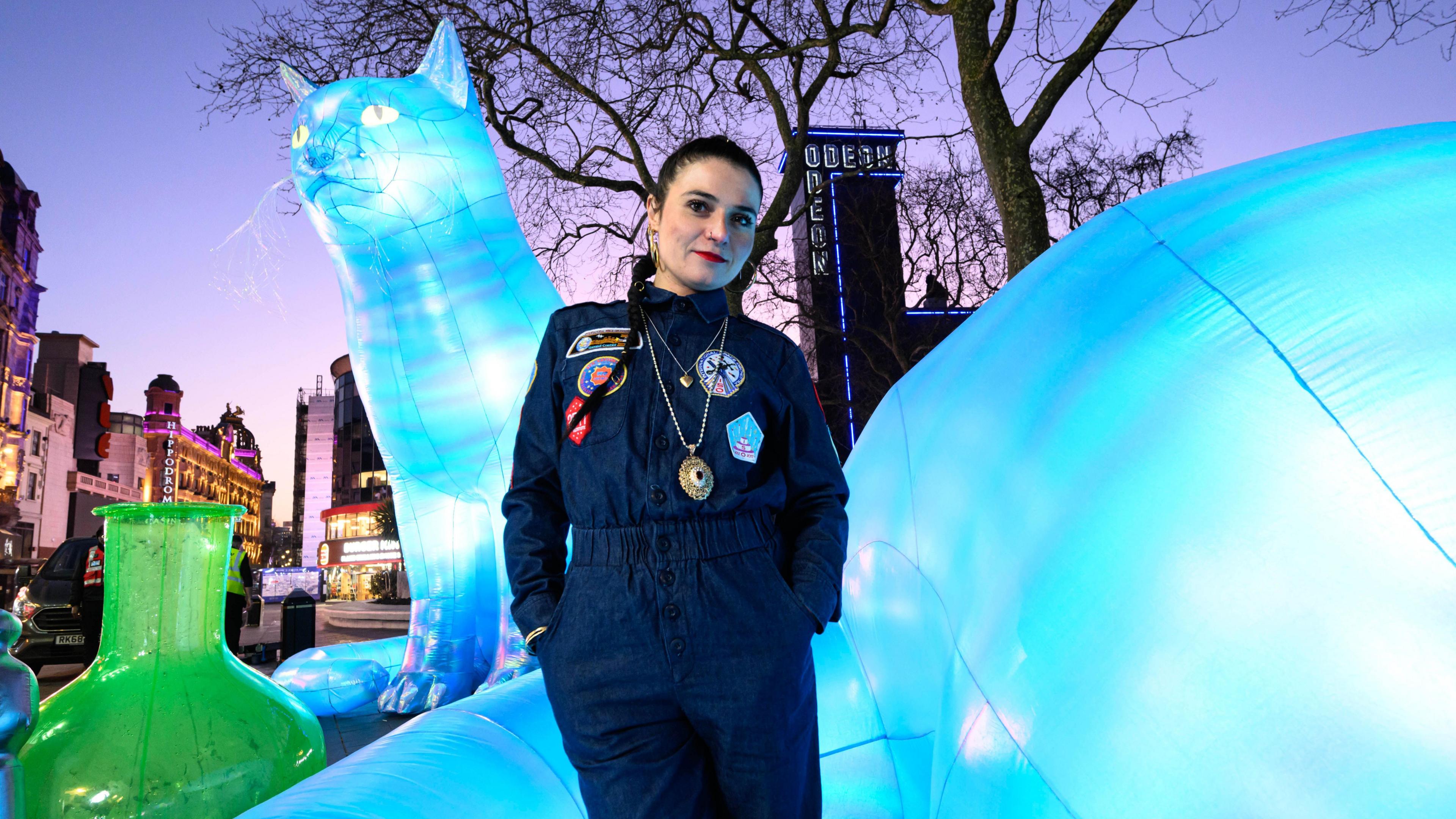 Nelly Ben Hayoun-Stepanian looks at the camera in front of her large inflatable cat artwork