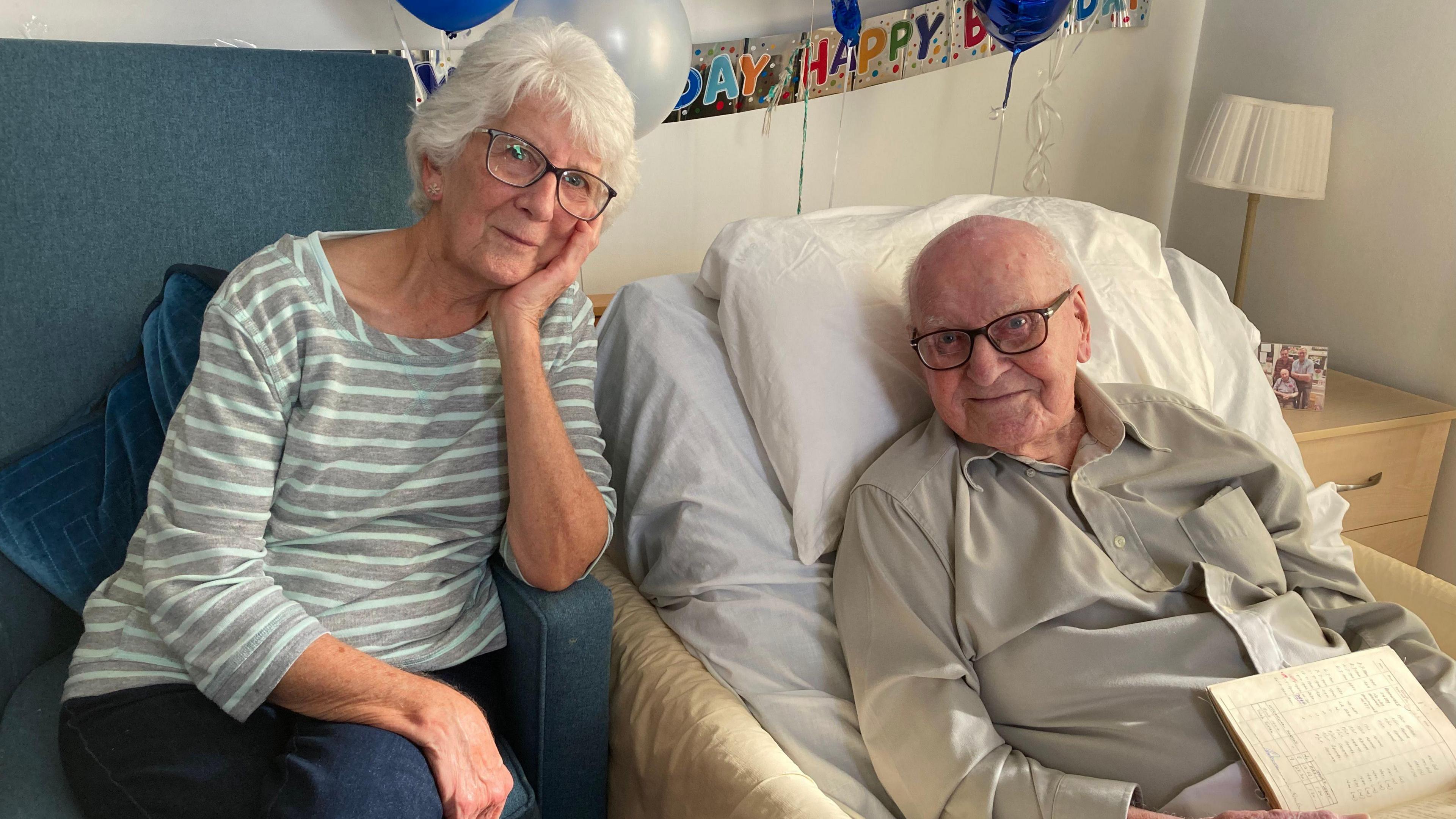 Shiela sits next to her father Arthur in bed