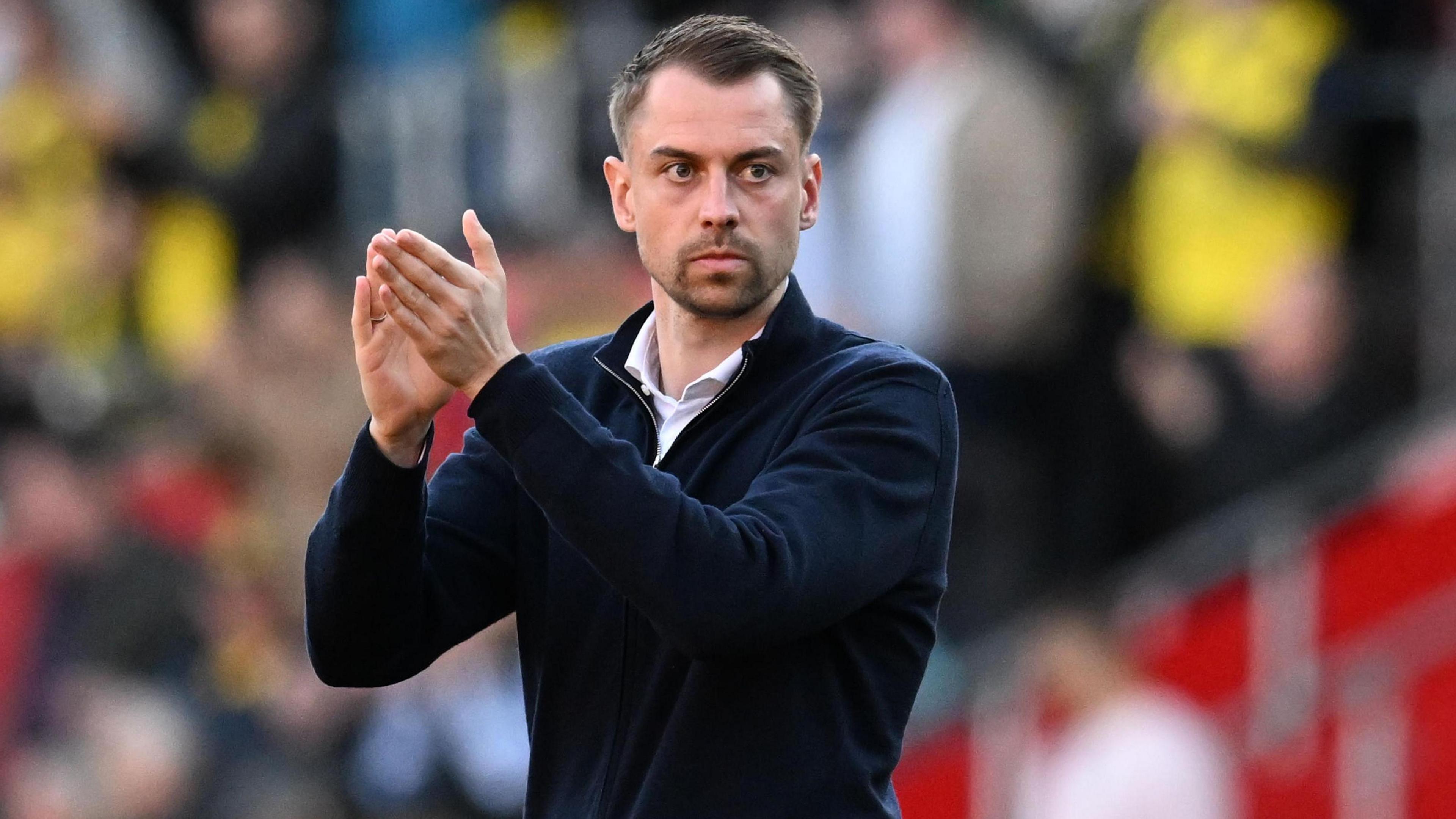 Southampton boss Tonda Eckert in a navy blue jumper and white shirt applauds supporters