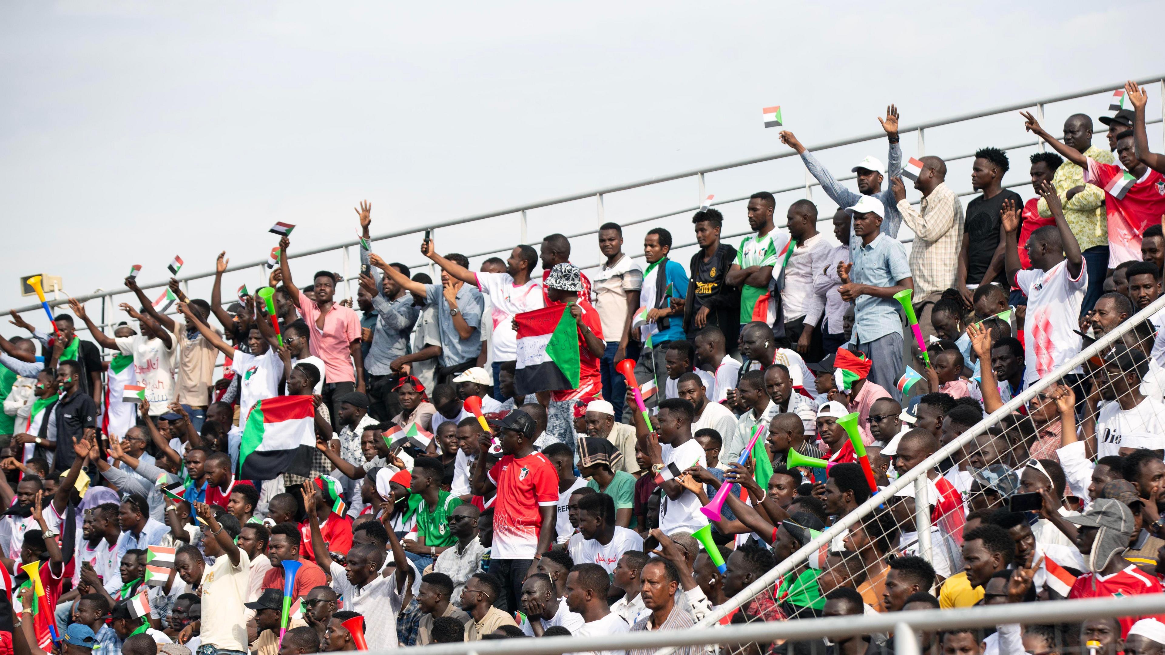 Sudan fans, some waving flags, in the stands in Juba