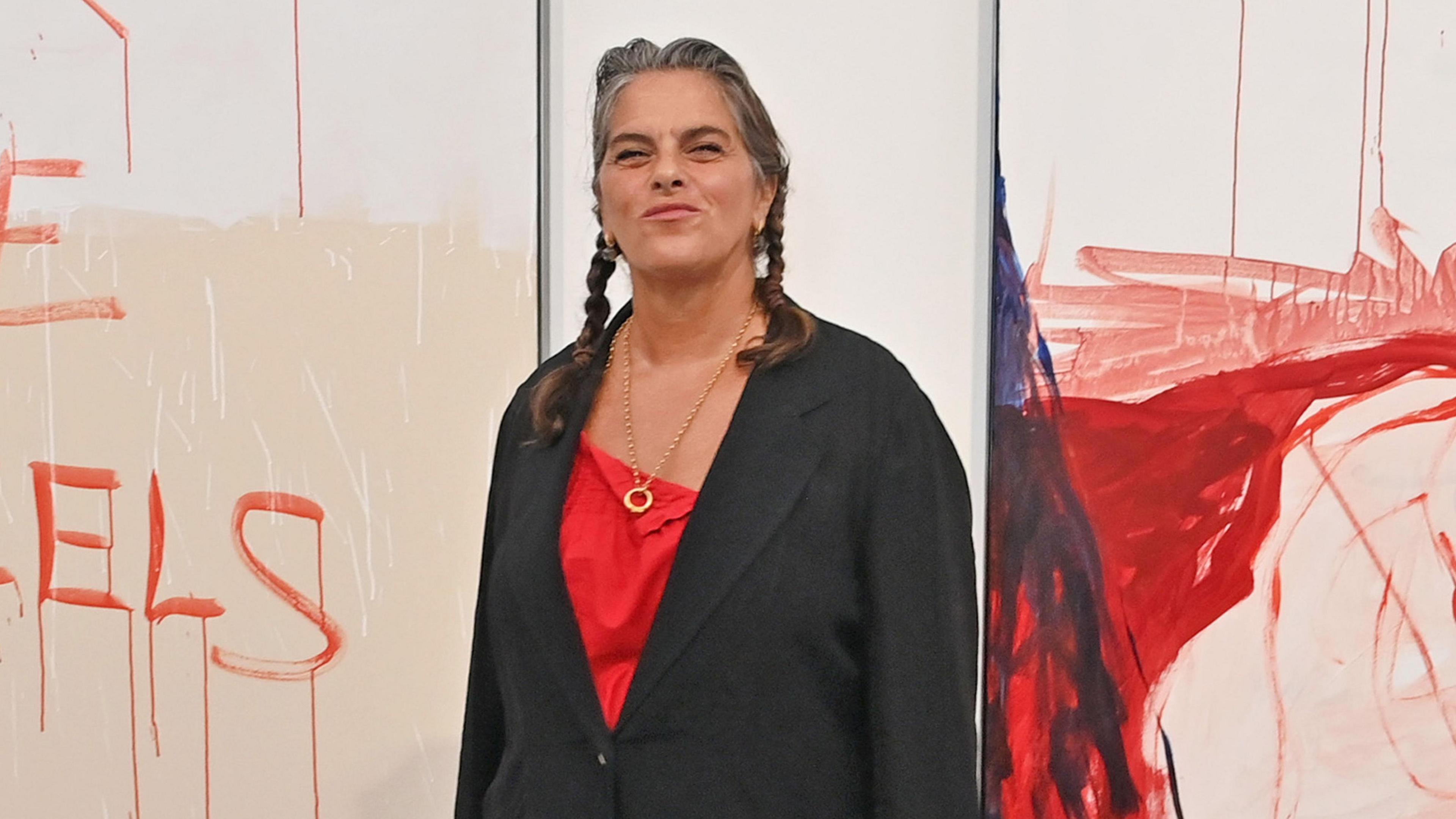 Tracey Emin attends a private view of 'I Followed You To The End' by Tracey Emin at White Cube Bermondsey on September 18, 2024 in London, England. She wears a dark jacket and a red blouse, with her hair in plaits.