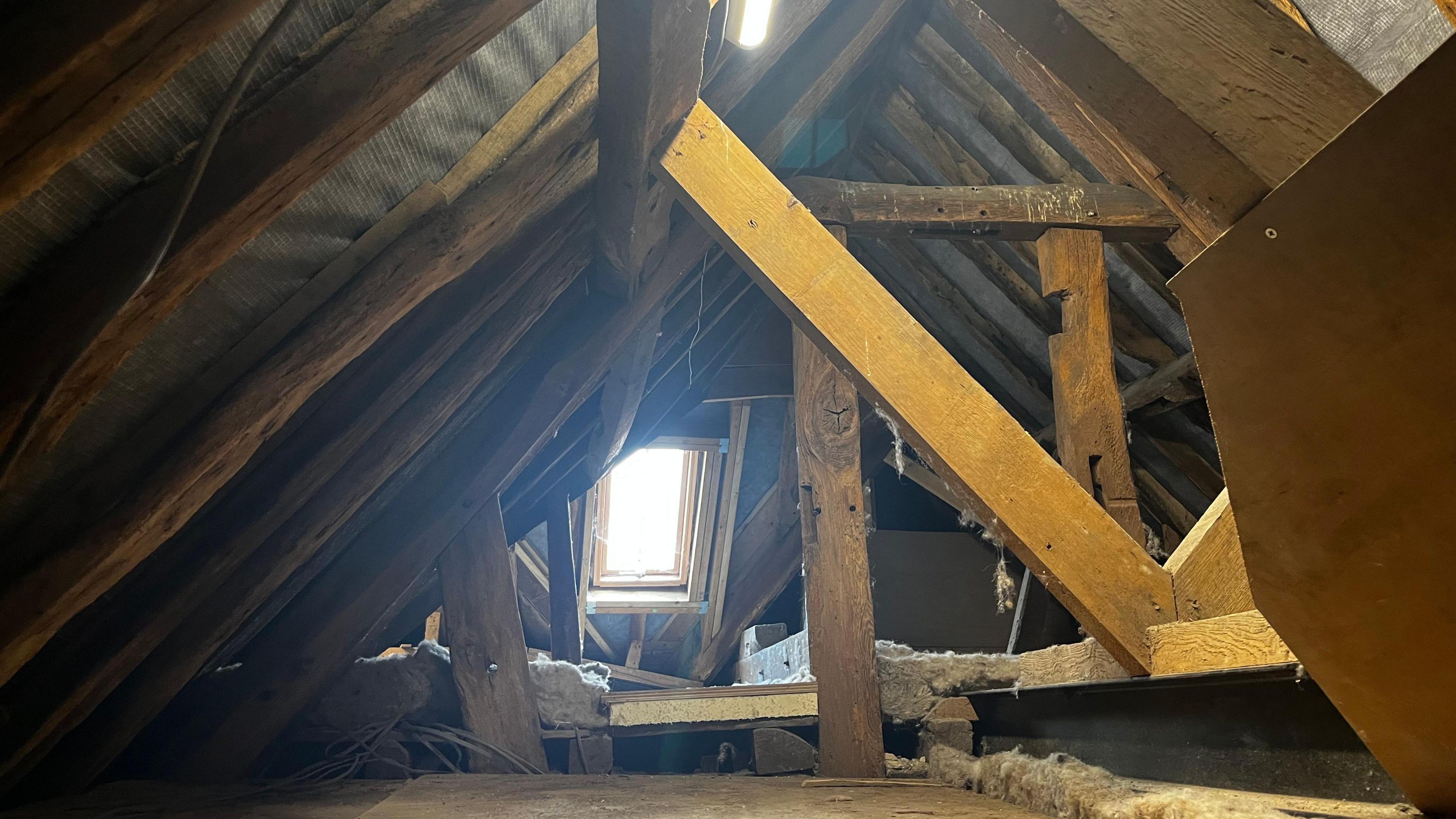 A view of the refurbished roof space with a window at the end letting in some light