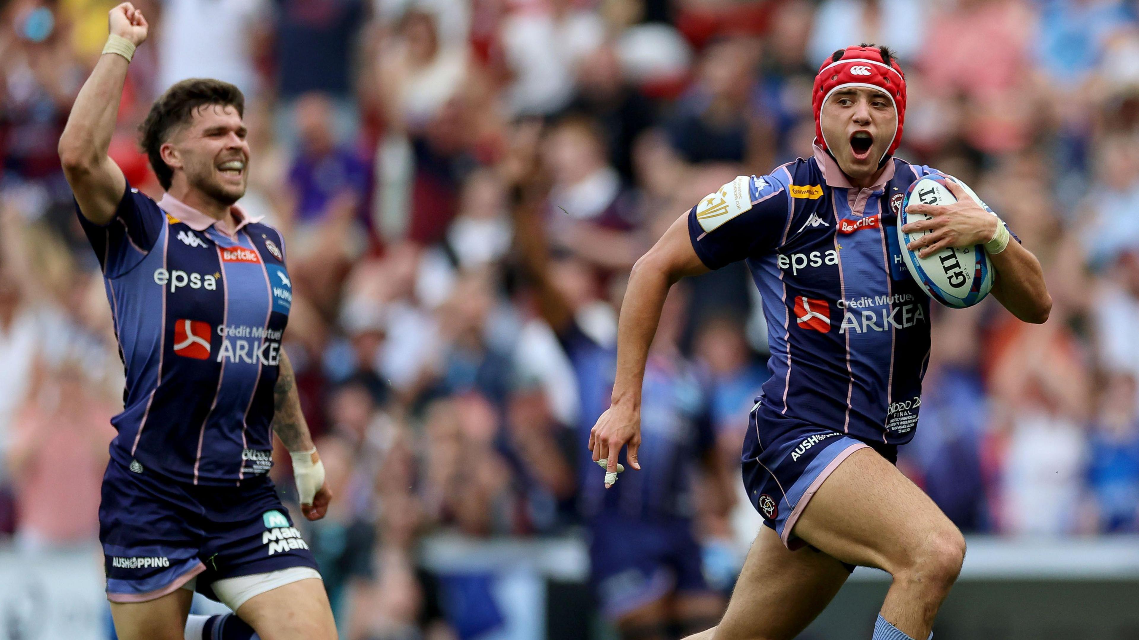 Louis Bielley Biarrey, in Bordeaux-Begles' blue striped kit, runs away with the ball in his hand on his way to scoring a try