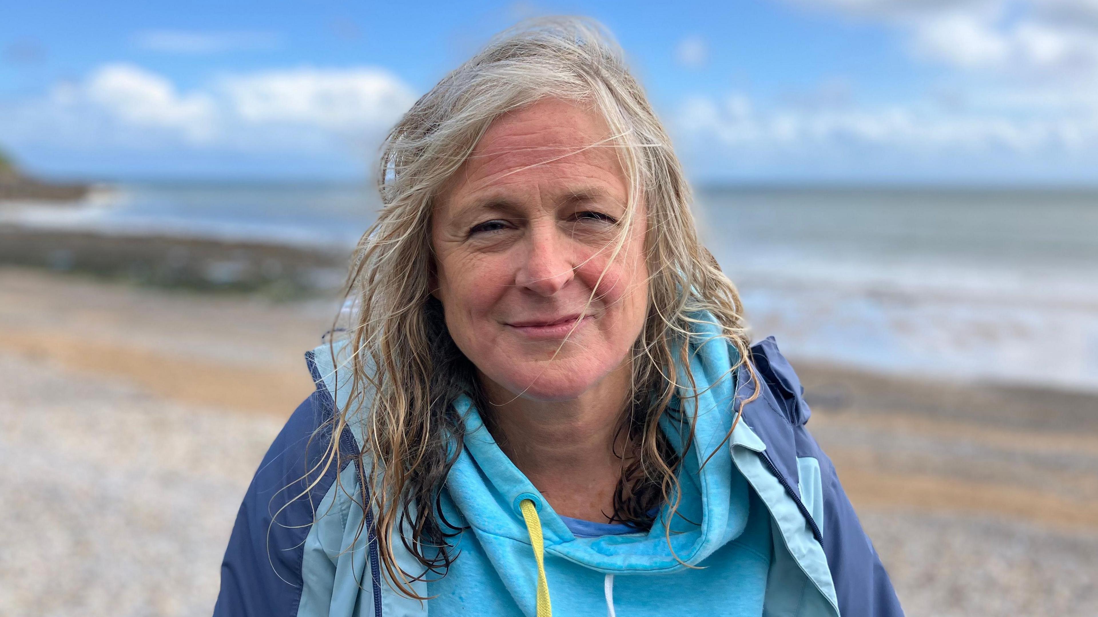 Woman with grey/blonde hair looking at the camera