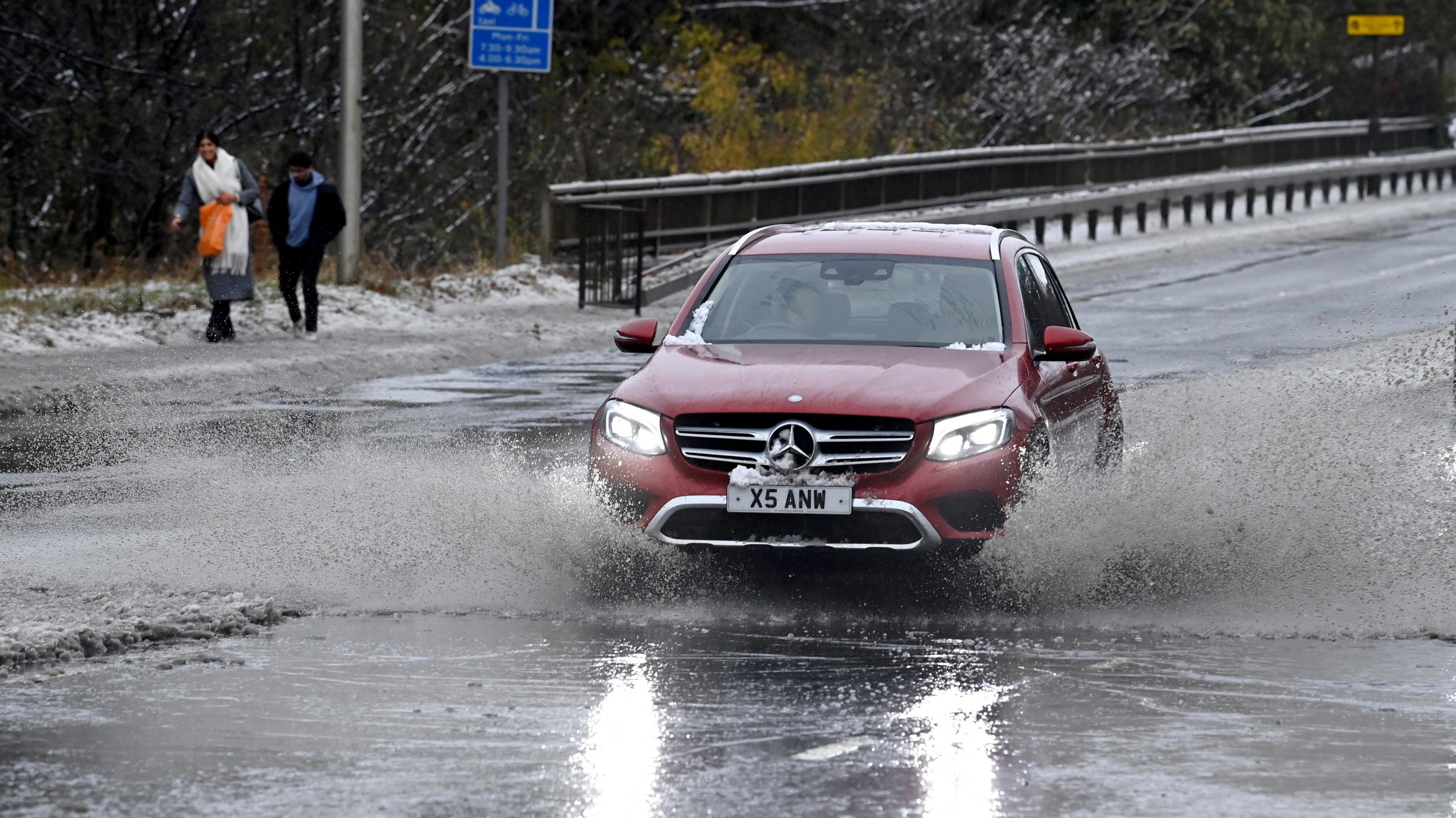 A car drives through deep water from Storm Bert along the A90 near Edinburgh