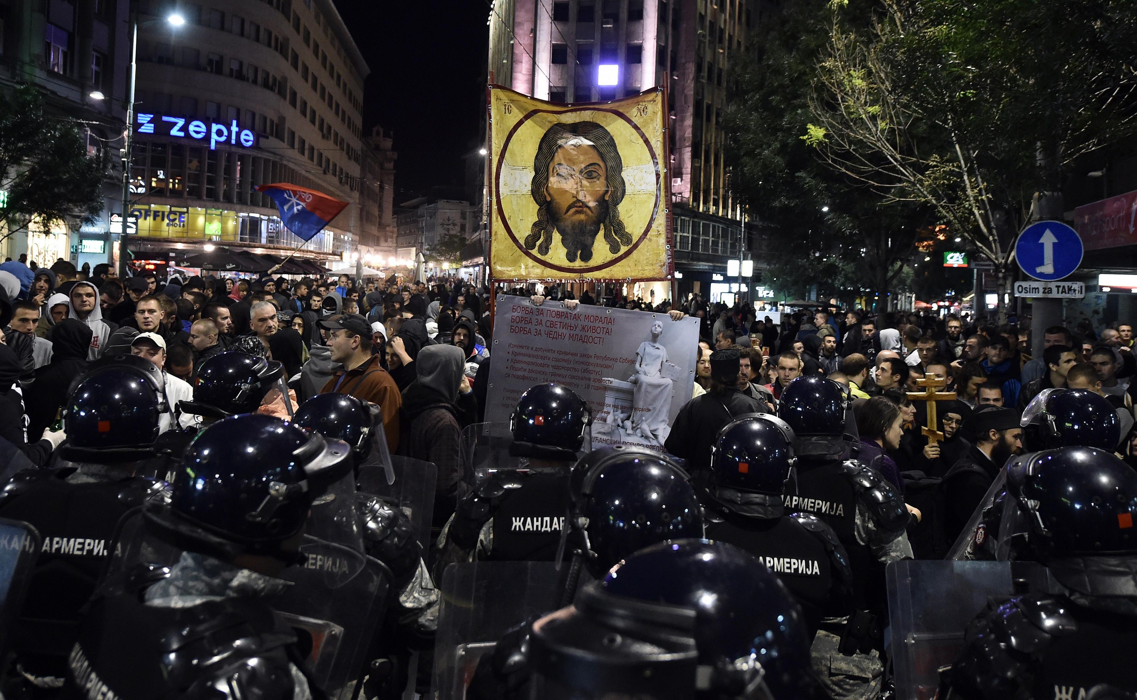 Anti-gay protestors surrounded by police at Belgrade Pride in 2014.