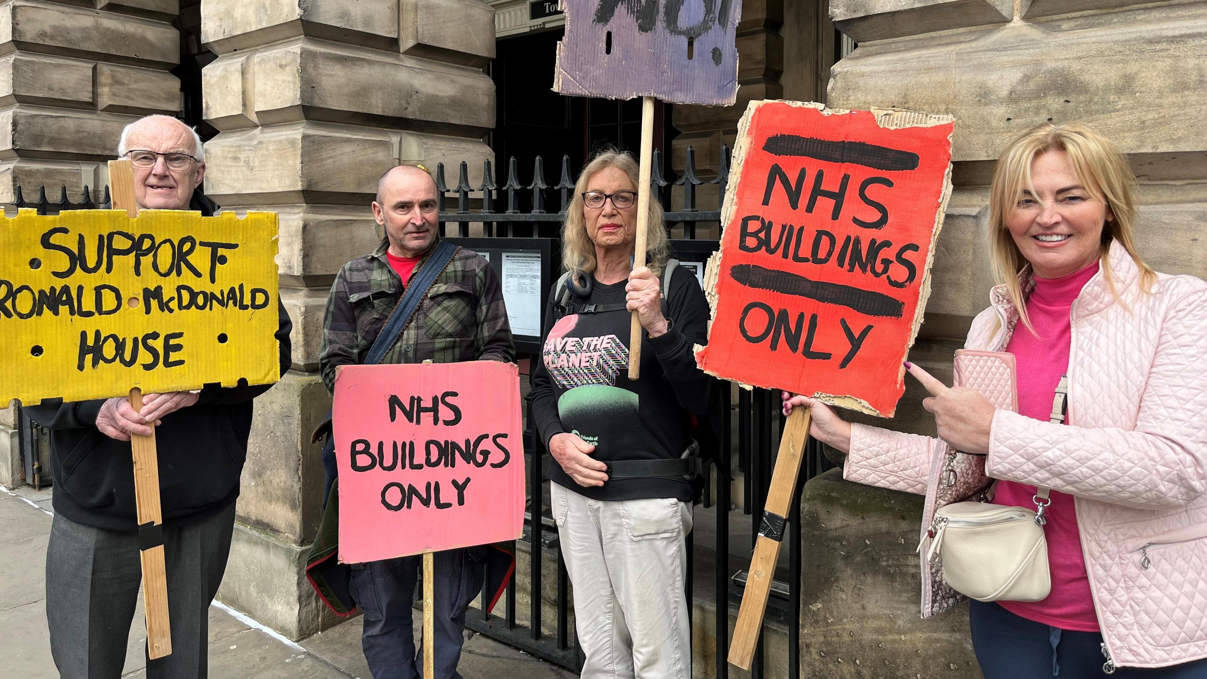 Protestors outside Liverpool Town Hall holding placards