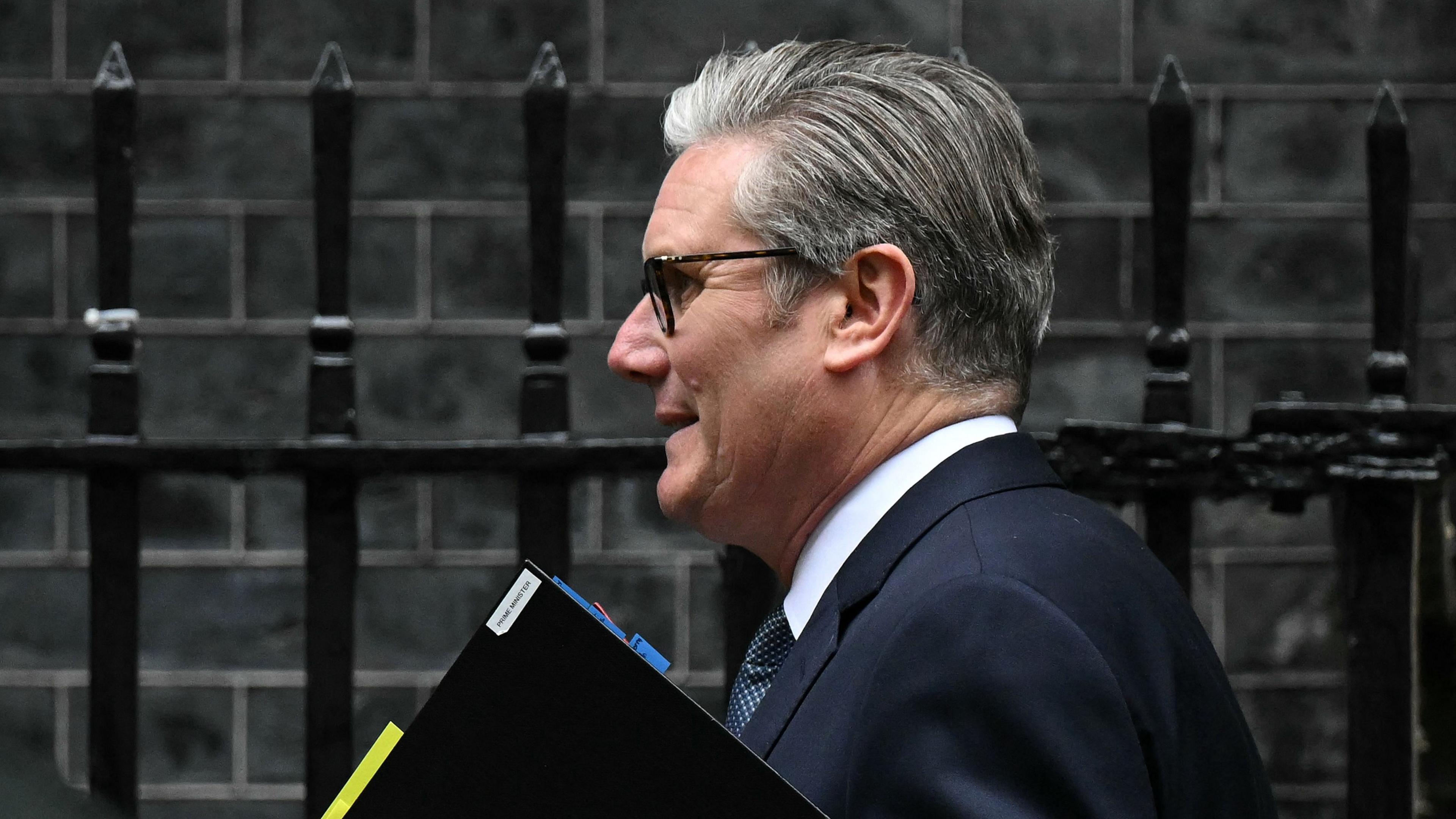 Sir Keir Starmer leaves No 10 carrying a folder.