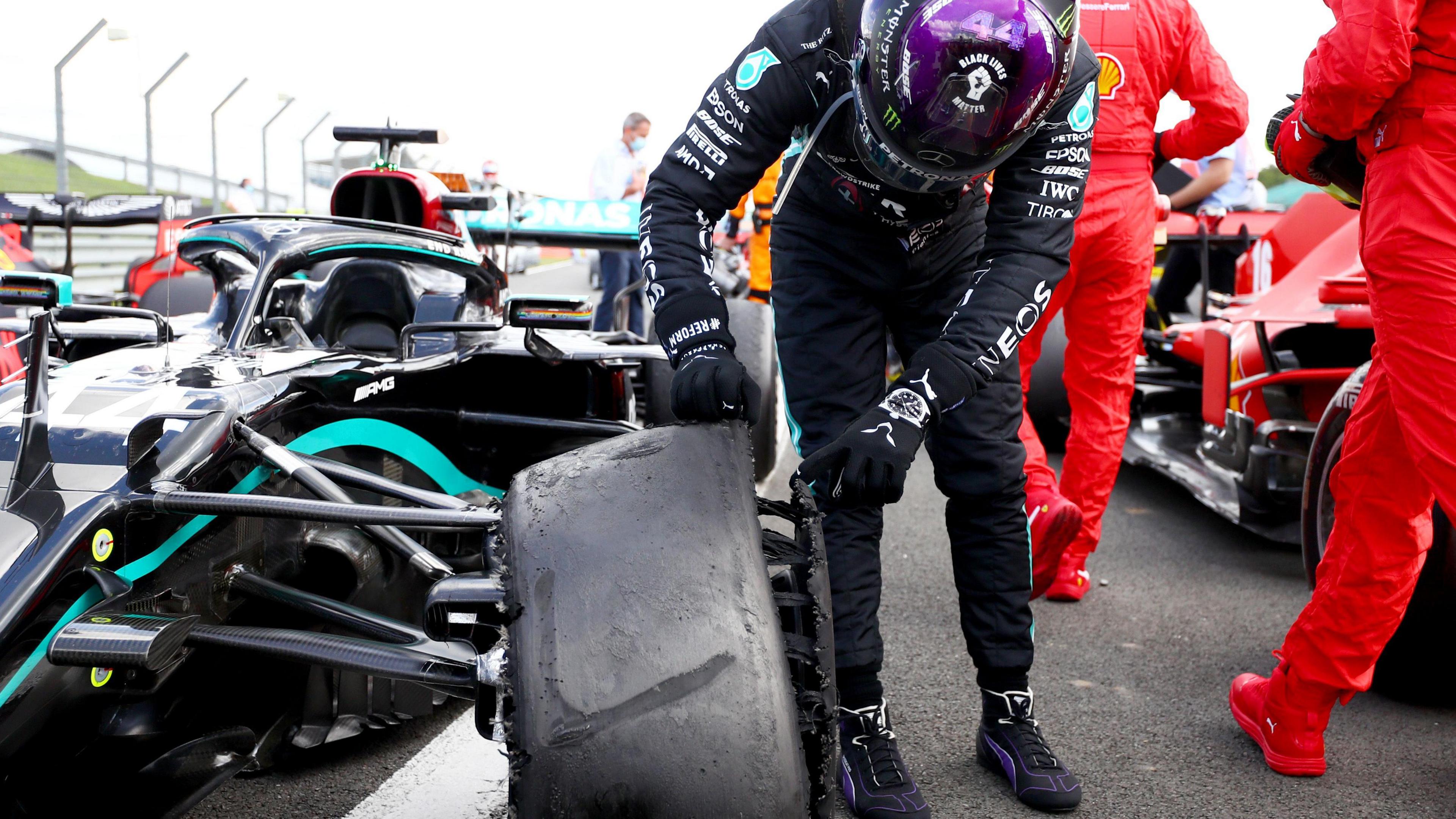 Lewis Hamilton inspects his punctured front left tyre after he finished the 2020 grand prix on three wheels. The puncture happen on the final lap but Hamilton was able to get round for the win