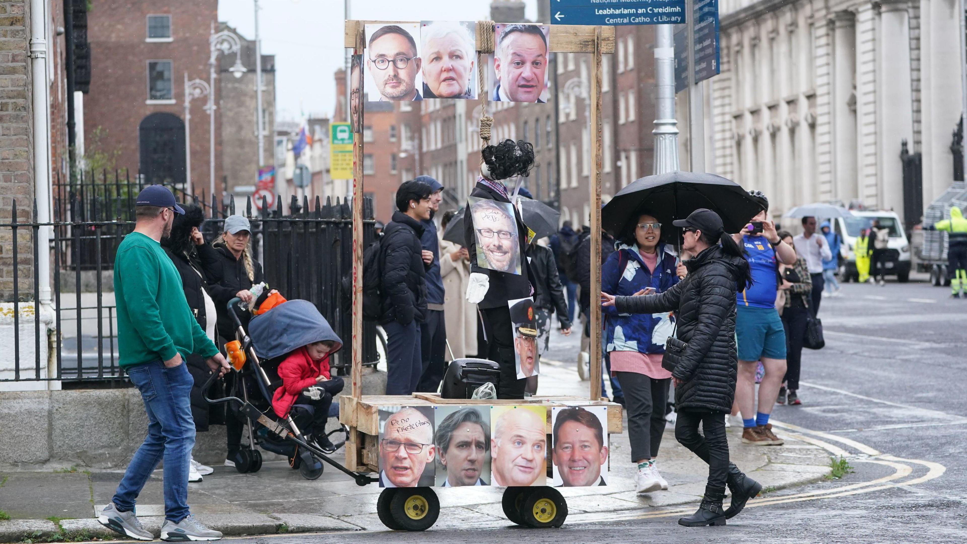 Gallows with an effigy hanging from it and pictures of politicians