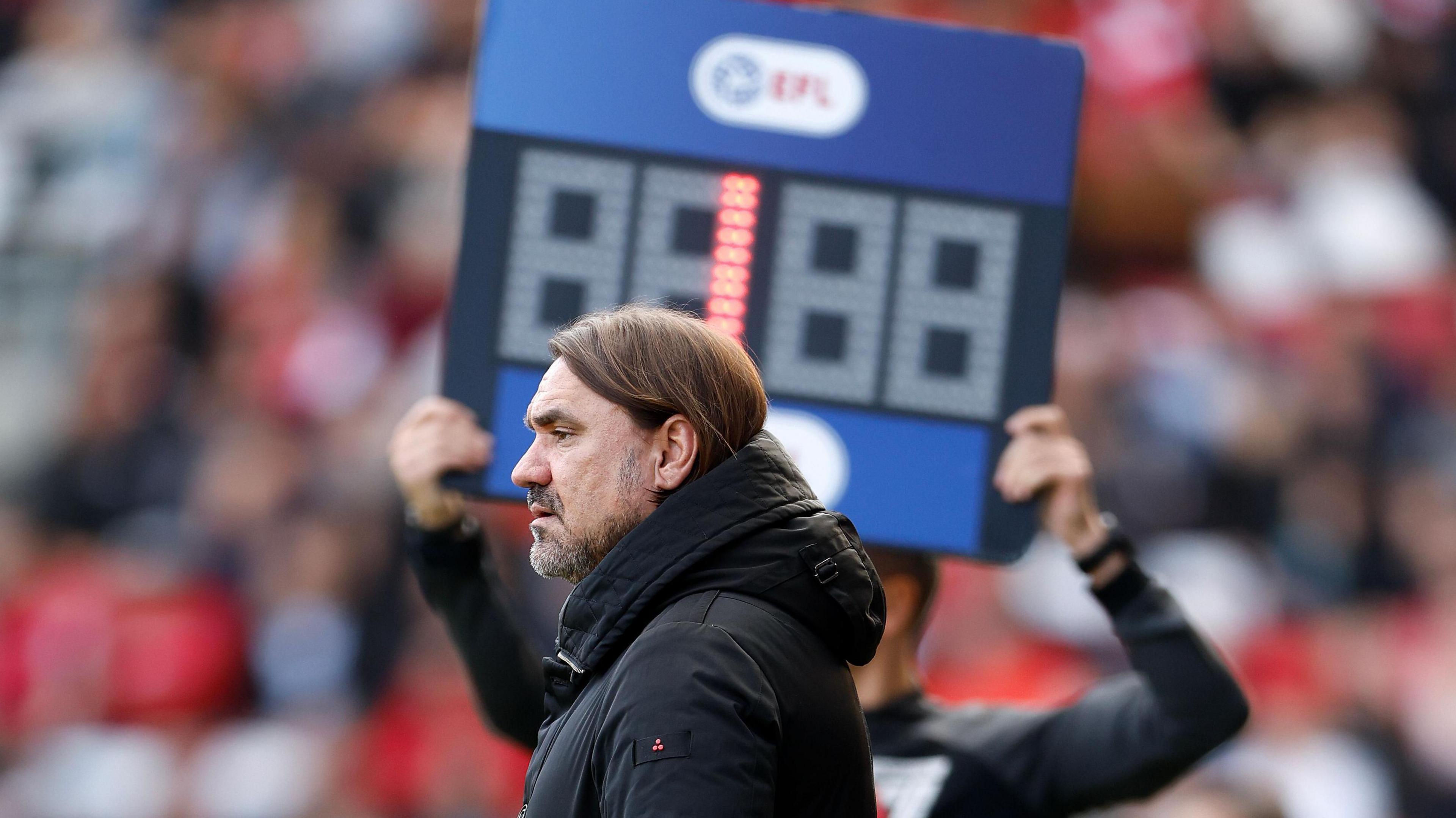 Daniel Farke stands infront of a board with number one on it