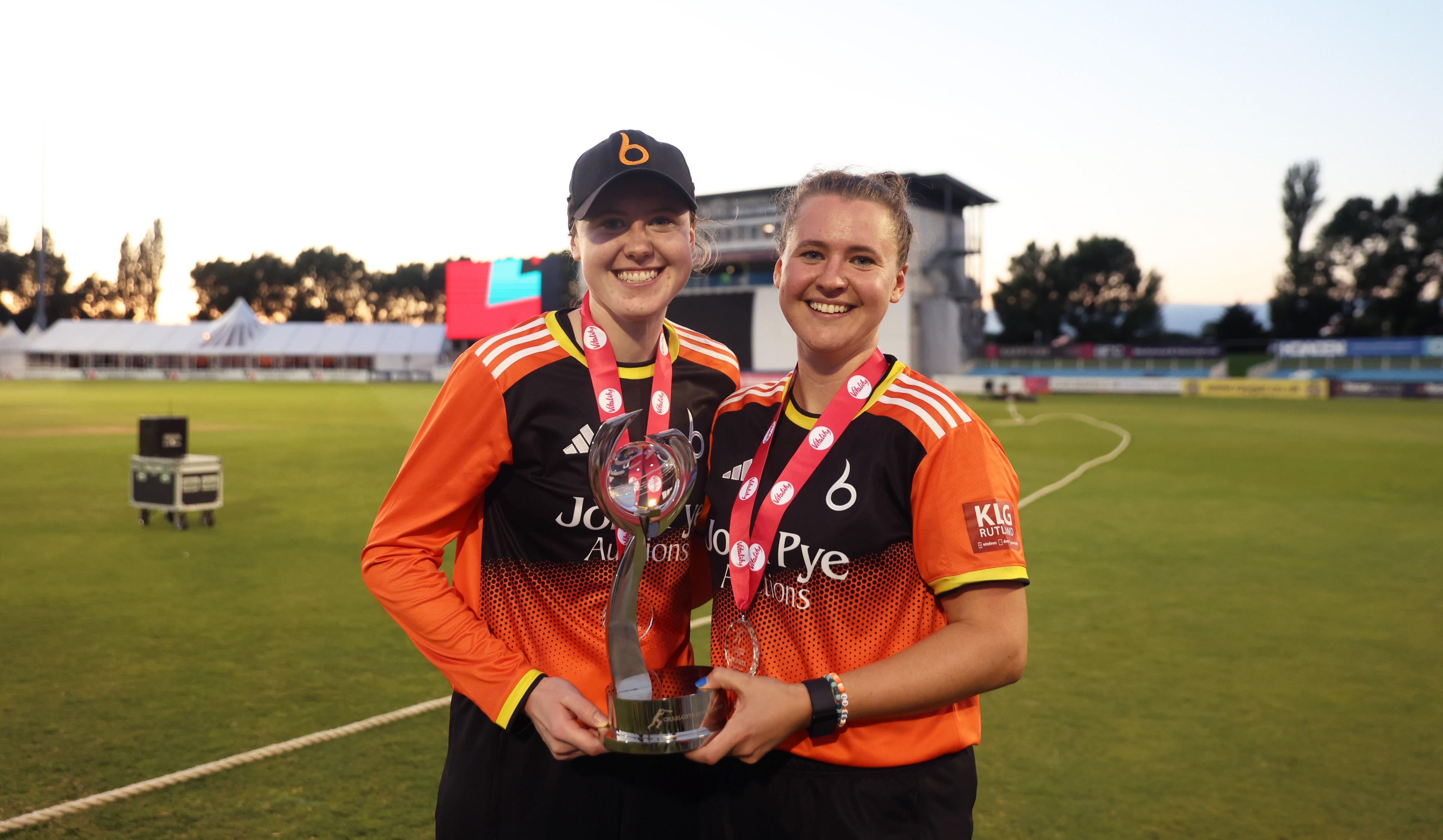 Sarah and Kathryn Bryce hold the Charlotte Edwards Cup