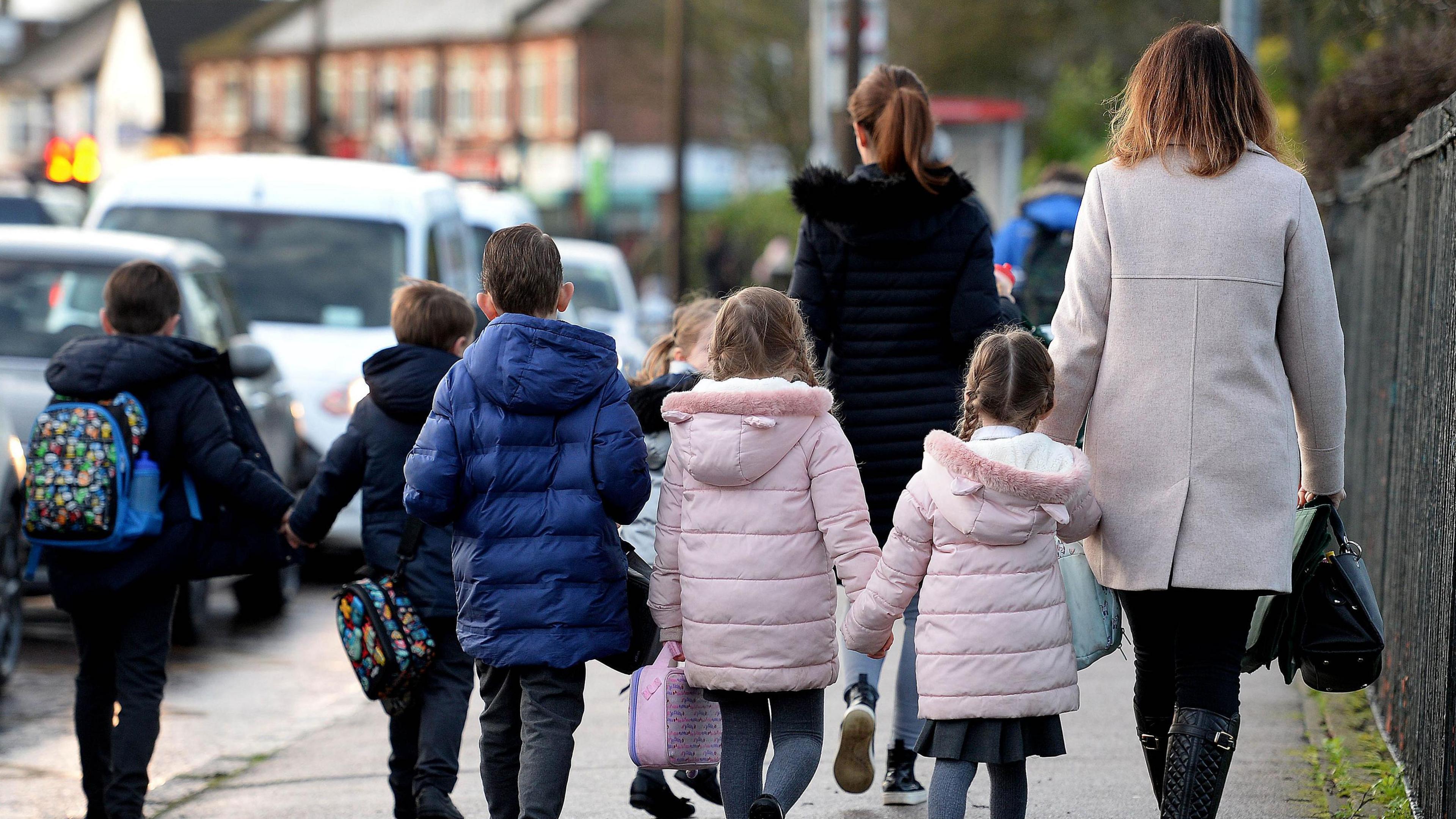 Parents walking their children to school