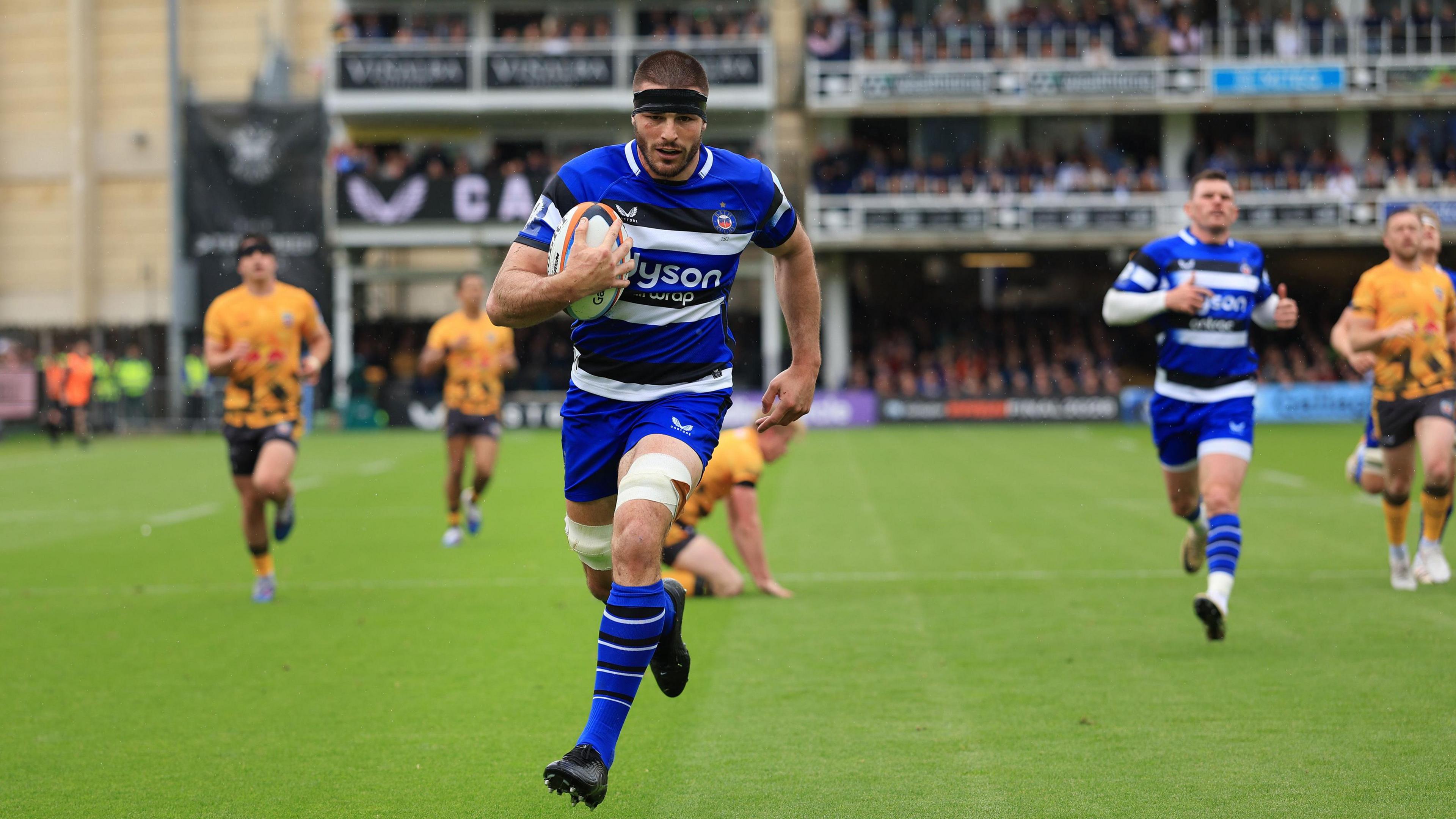 Josh Bayliss runs with the ball under his right arm towards the try line against Newcastle