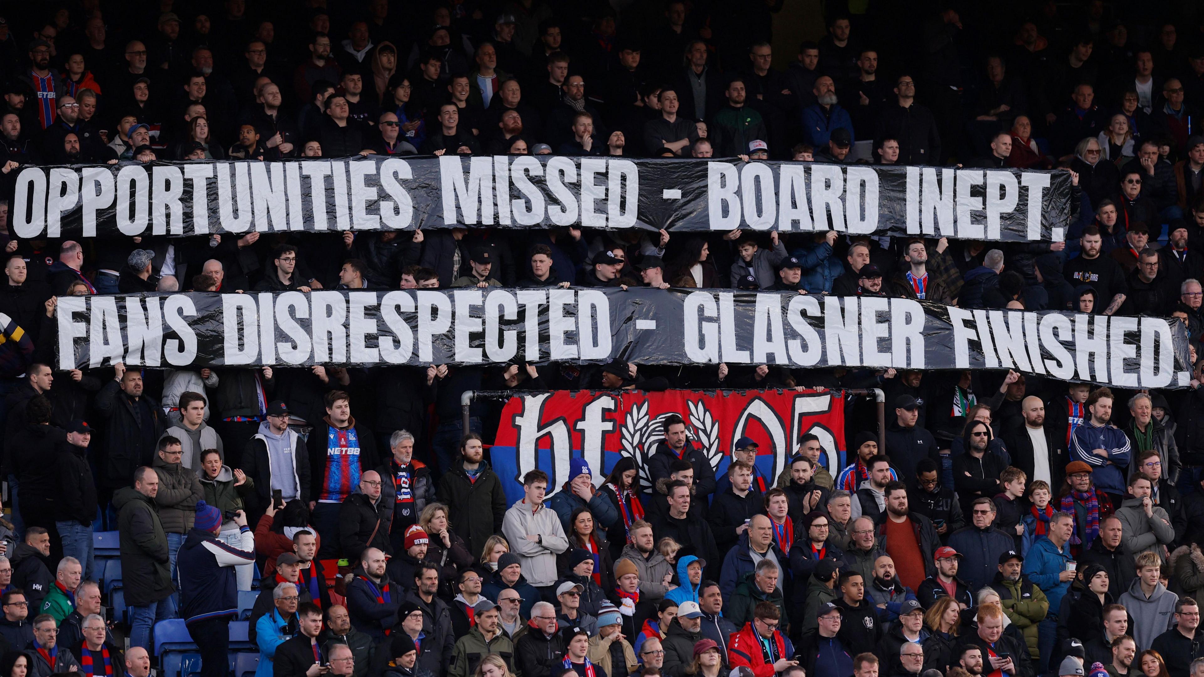 Crystal Palace fans holding banners during their win over Wolves which call the club's board "inept" and say that manager Oliver Glasner is "finished"
