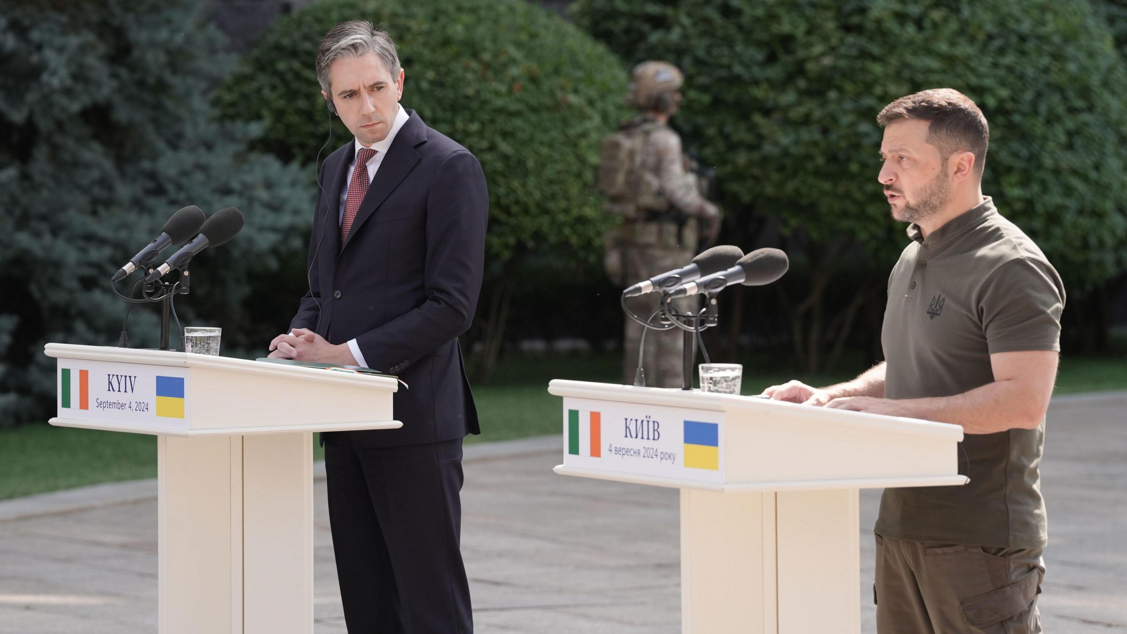 Simon Harris and Volodymyr Zelensky speaking at podiums outside