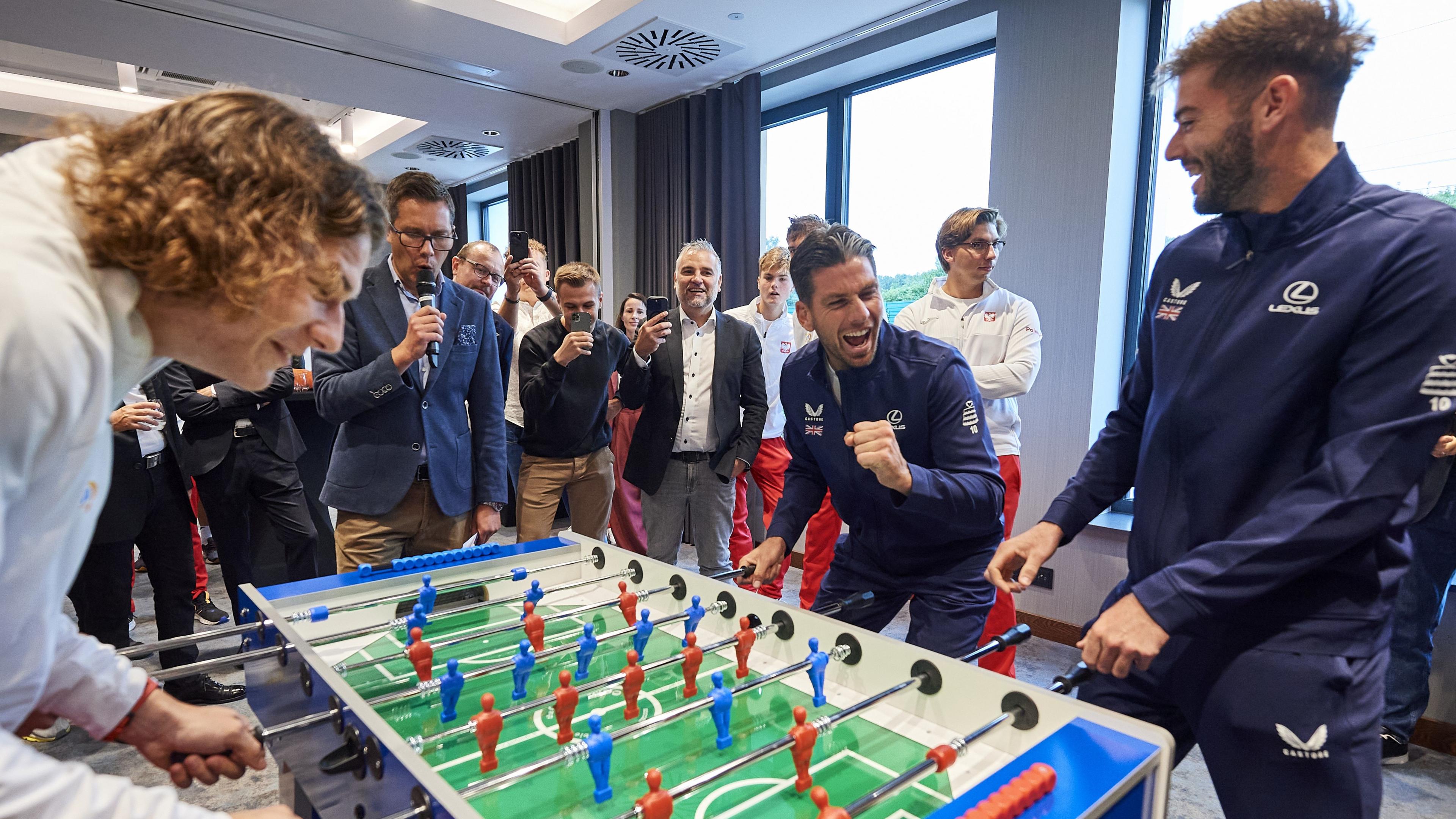 Cameron Norrie and Jacob Fearnley laughing while playing table football
