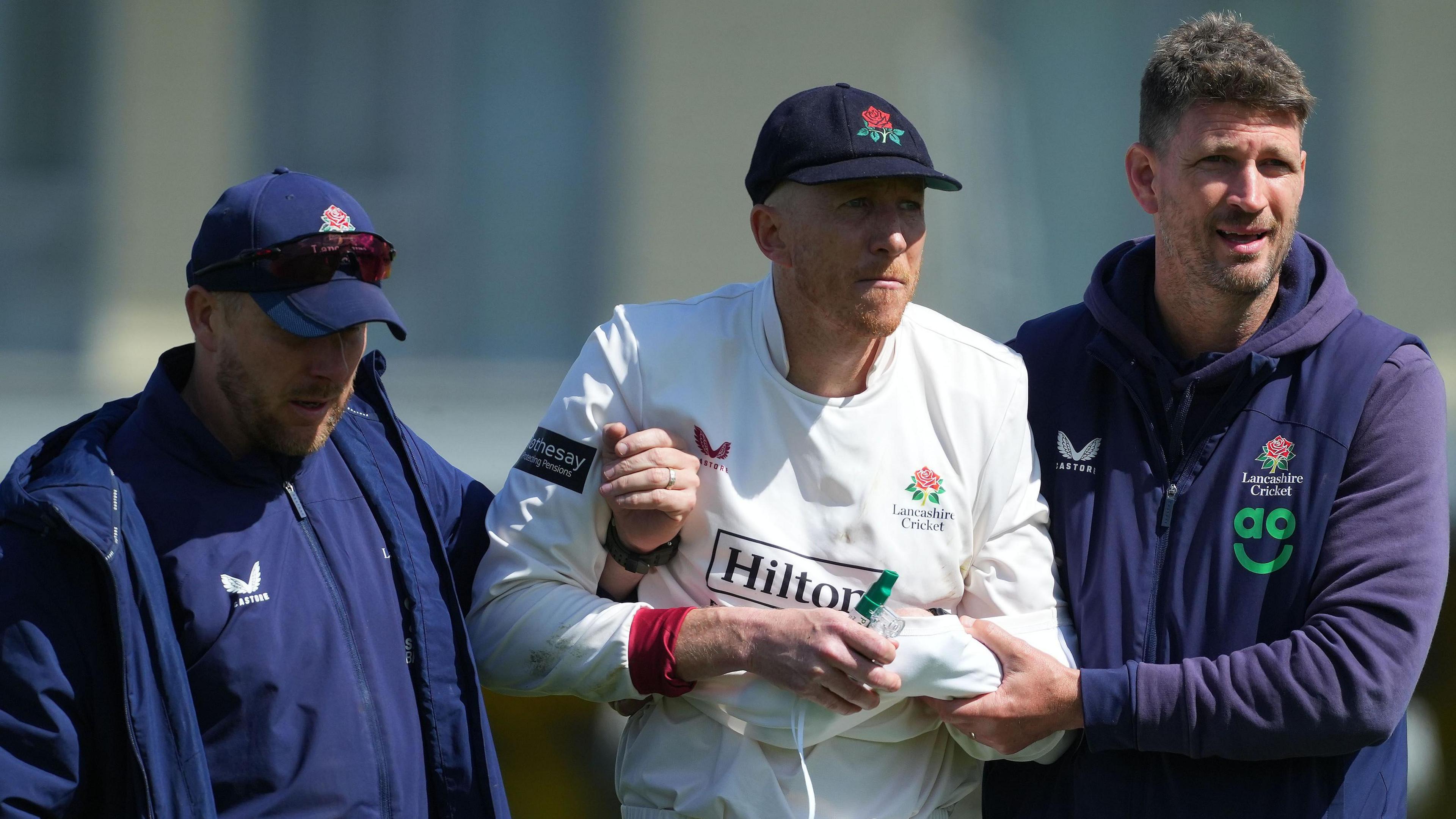 Luke Wells is helped from the field having injured himself during Lancashire's Division Two fixture at Gloucestershire